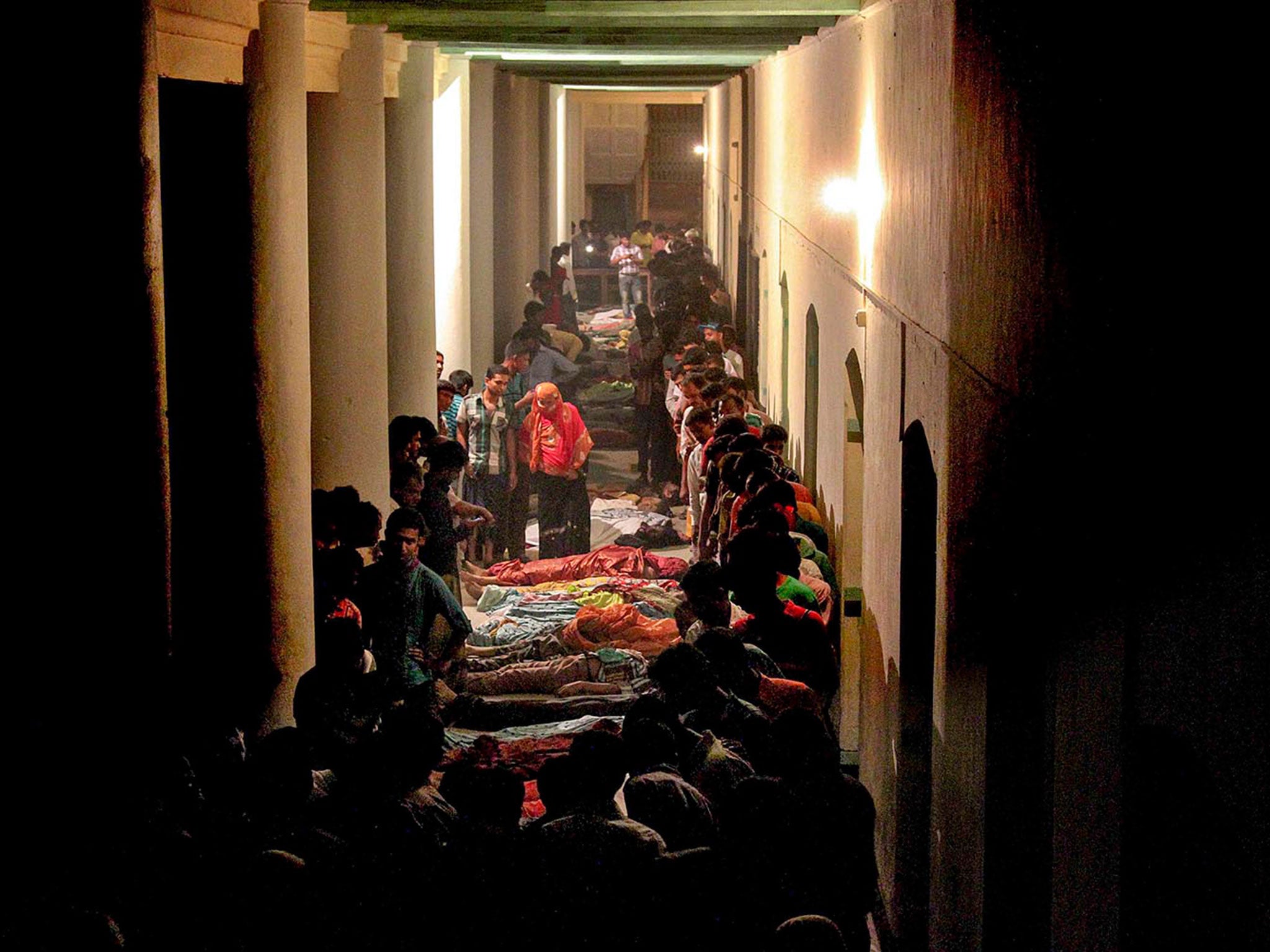 People in search of their missing relatives gather around the bodies kept in a long passage in a school building near the collapsed Rana Plaza in Savar as the rescuers were facing difficulties in managing so many dead bodies © Palash Khan