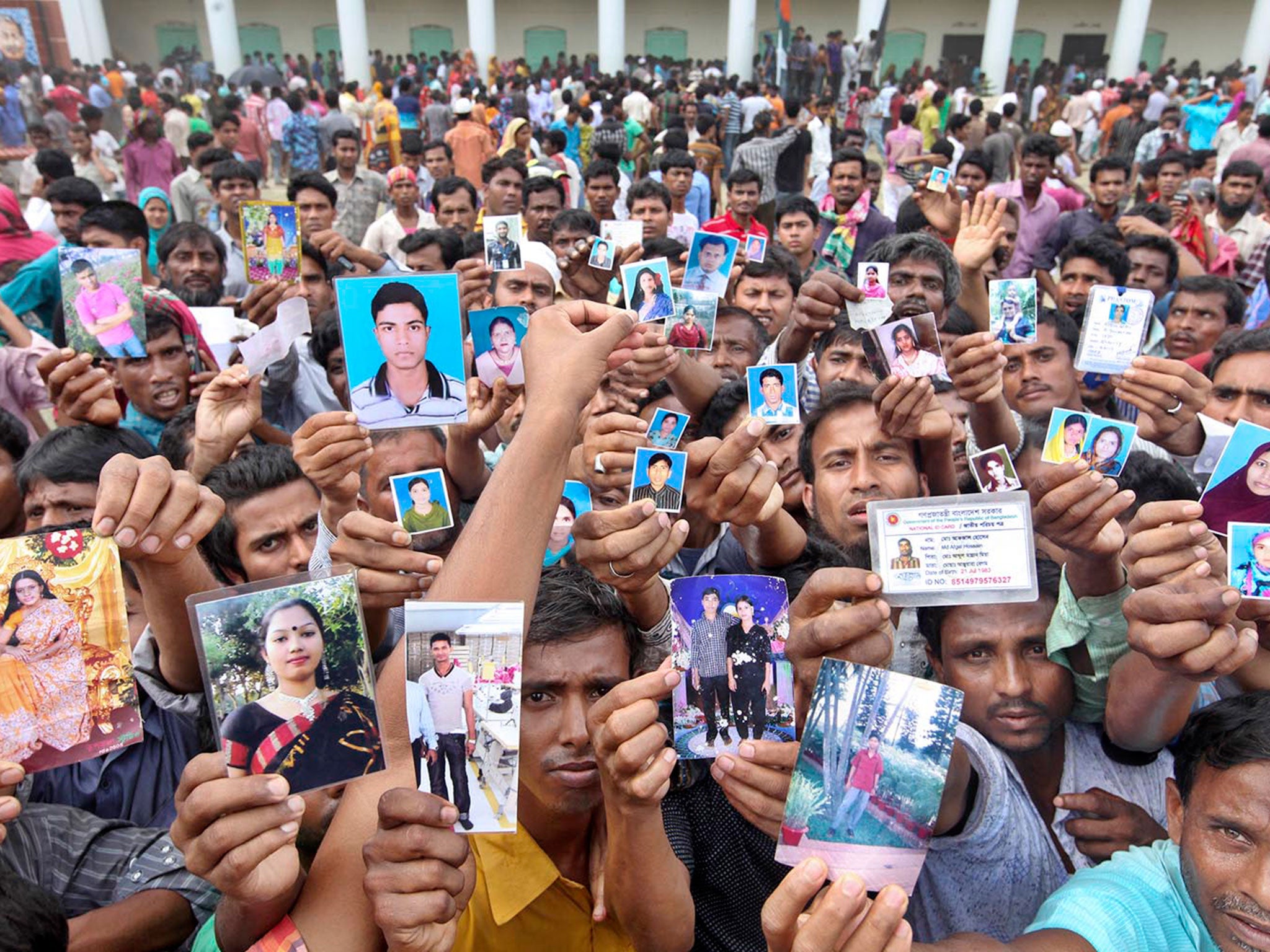 People hold photos to know the whereabouts of their missing relatives working at the Rana Plaza apparel factories © Rohat Ali Rajib