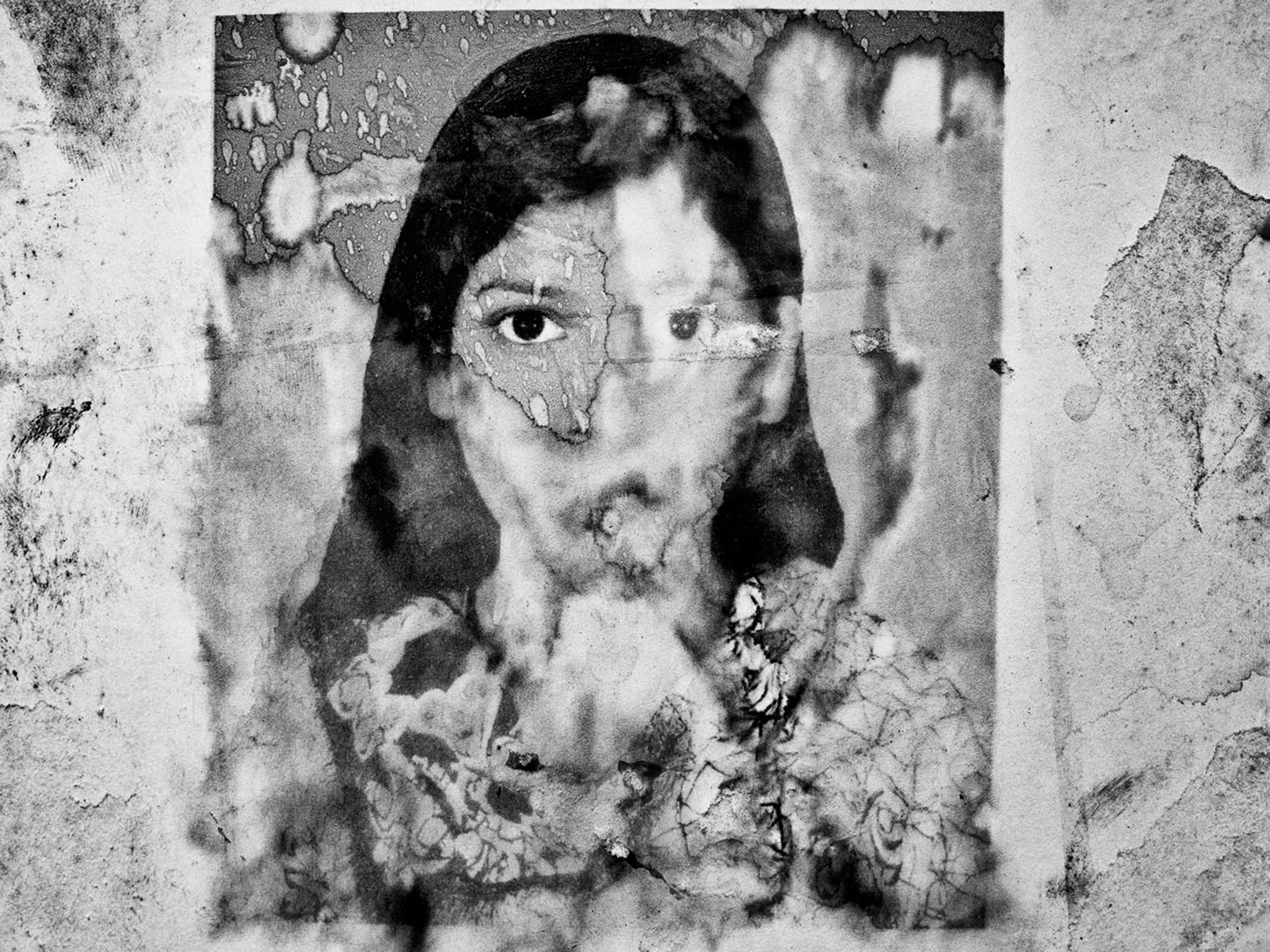 Rain washes out the photograph of Asma Akhter, a missing Rana Plaza garment worker, pasted up on the wall of Adhar Chandra High School in Savar, where the authorities open a makeshift camp to record the names of missing workers © Suvra Kanti Das