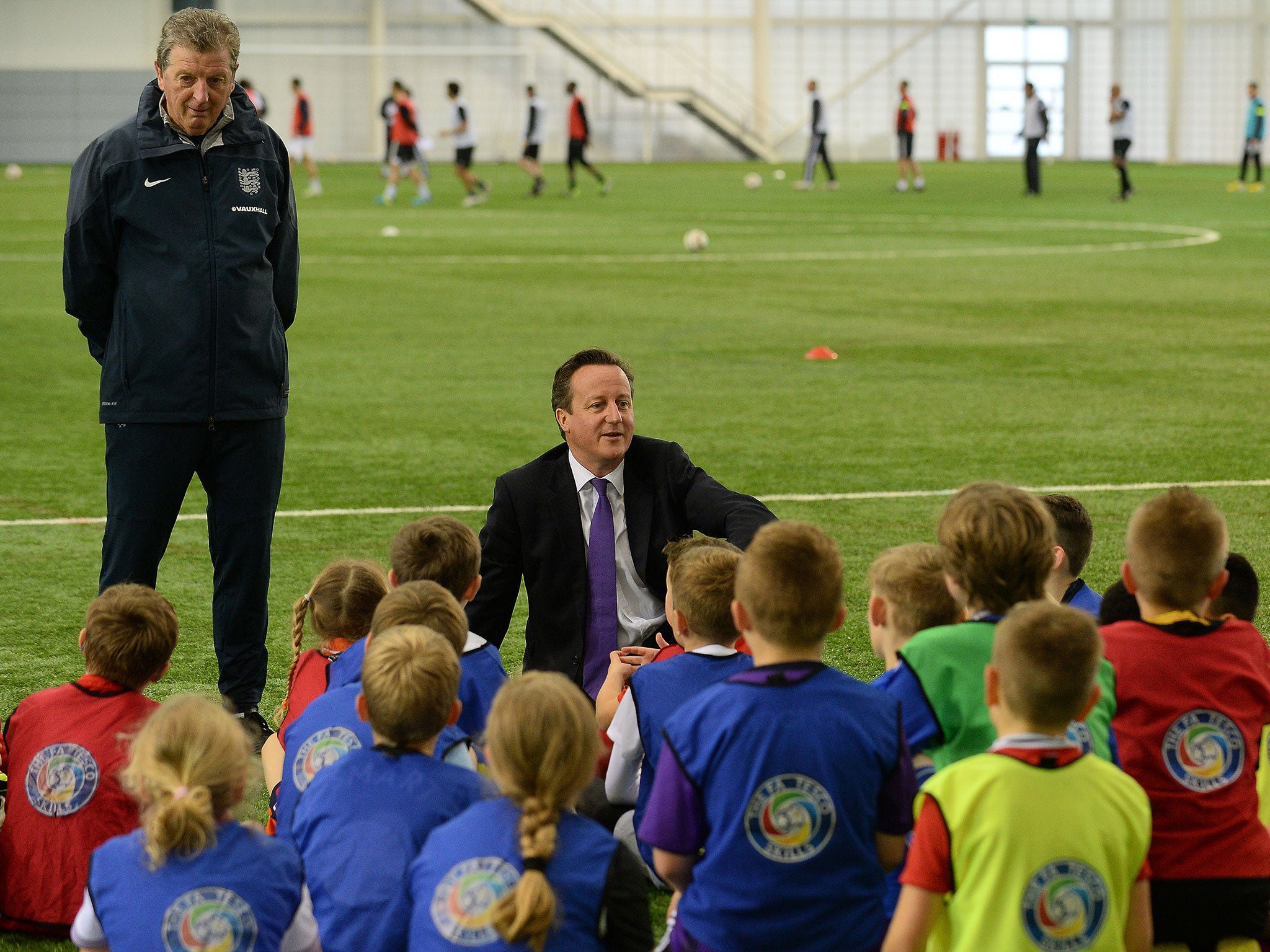David Cameron, (centre) with England manager Roy Hodgson (left), has included little about football in the Conservative manifesto