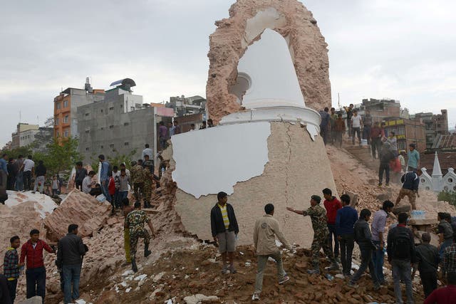 Nepalese rescue members and onlookers gather at the collapsed Darahara Tower in Kathmandu