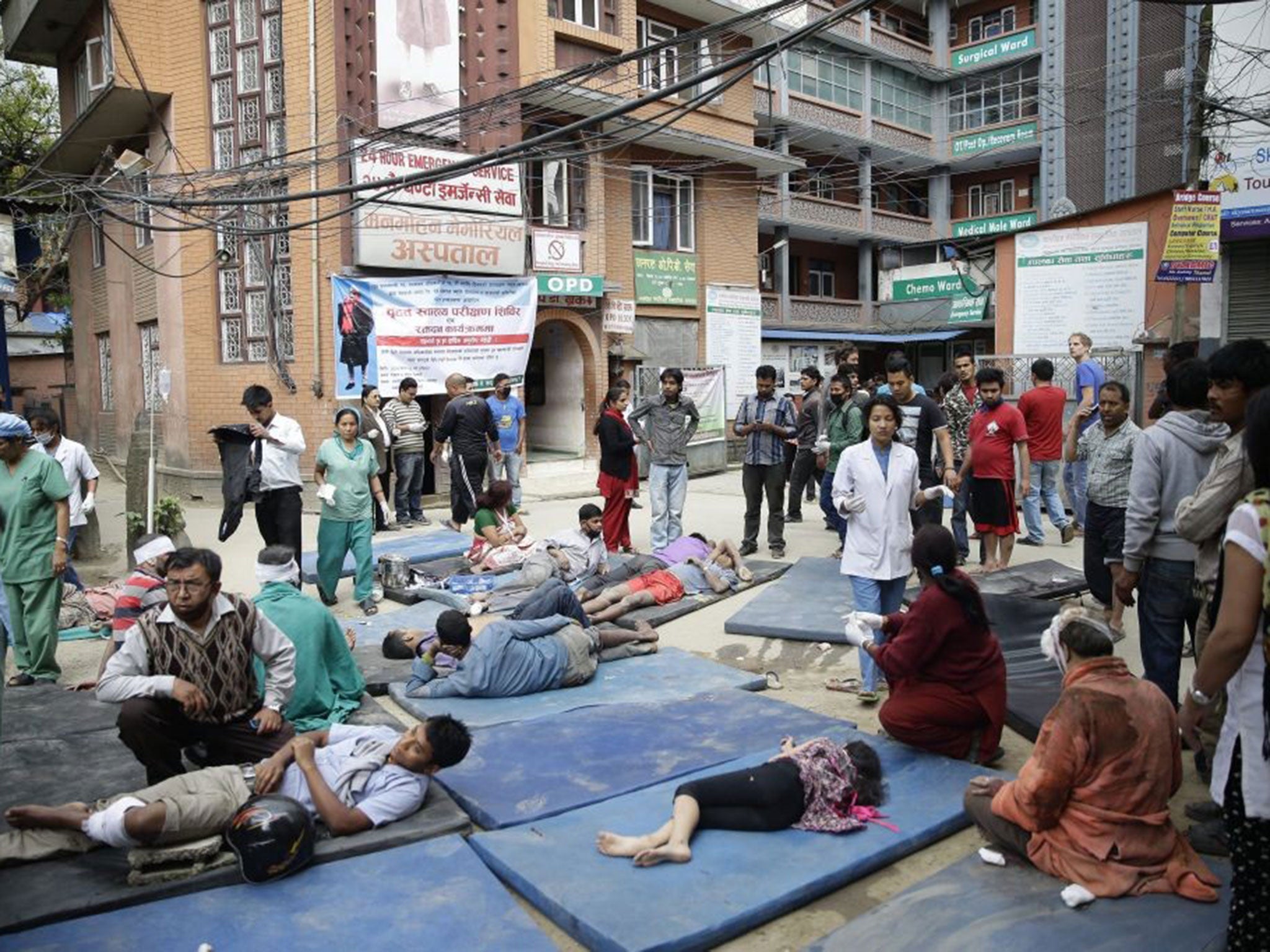 Health workers take care of injured people outside a hospital in Nepal