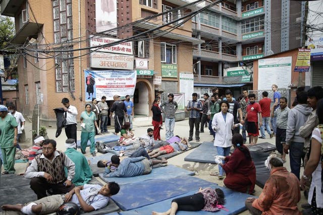Health workers take care of injured people outside the Manmohan Memorial Community Hospital after an earthquake caused serious damage in Kathmandu, Nepal