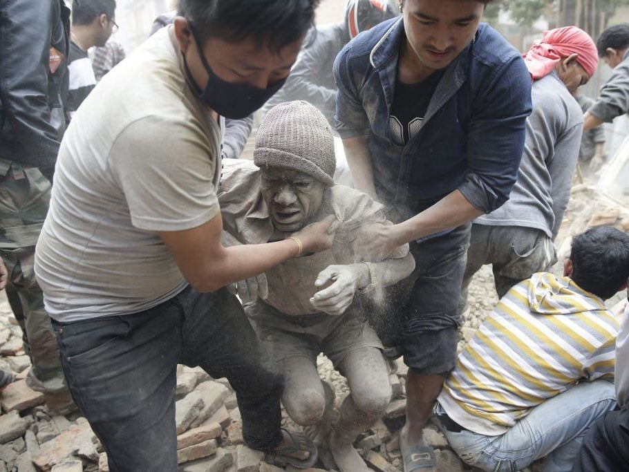 People free a man from the rubble of a destroyed building after an earthquake hit Nepal, in Kathmandu, Nepal