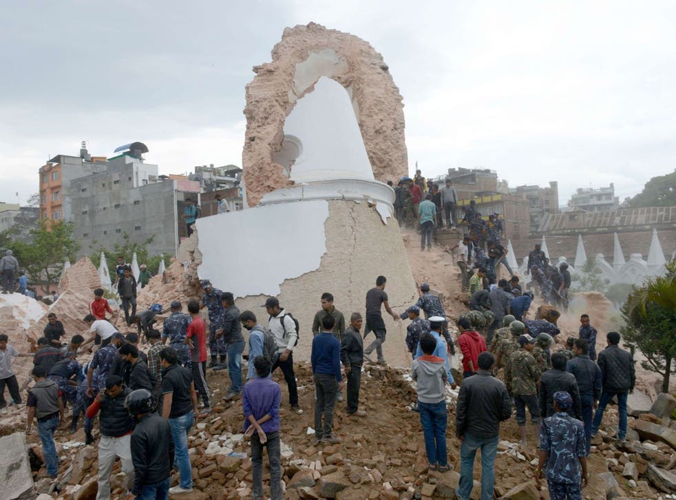 Nepalese rescue members and onlookers gather at the collapsed Darahara Tower in Kathmandu on April 25, 2015.