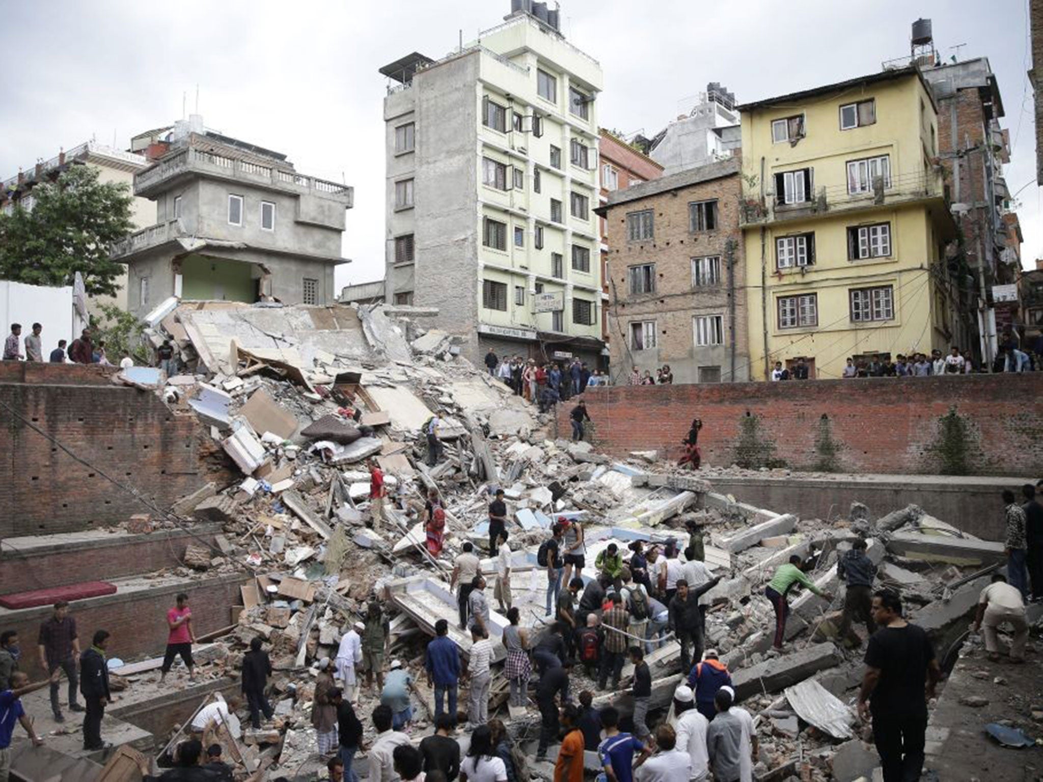 People search for survivors stuck under the rubble of a destroyed building, after an earthquake caused serious damage in Kathmandu, Nepal, 25 April 2015.