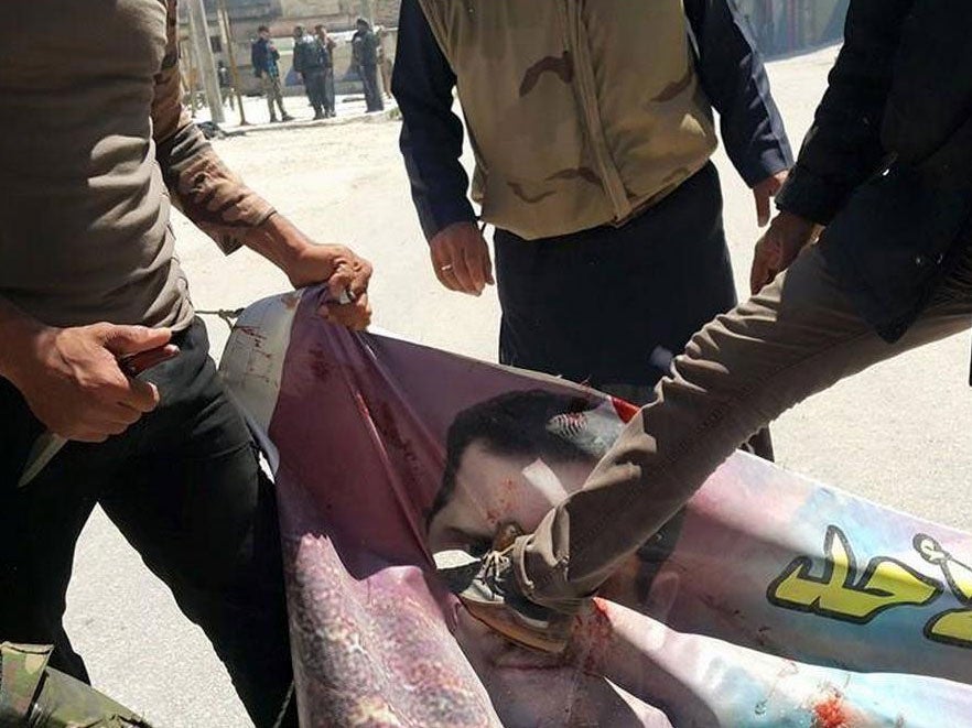 A photo claiming to show a banner picturing President Bashar al-Assad being destroyed after Islamists overran Jisr al-Shughour on Saturday