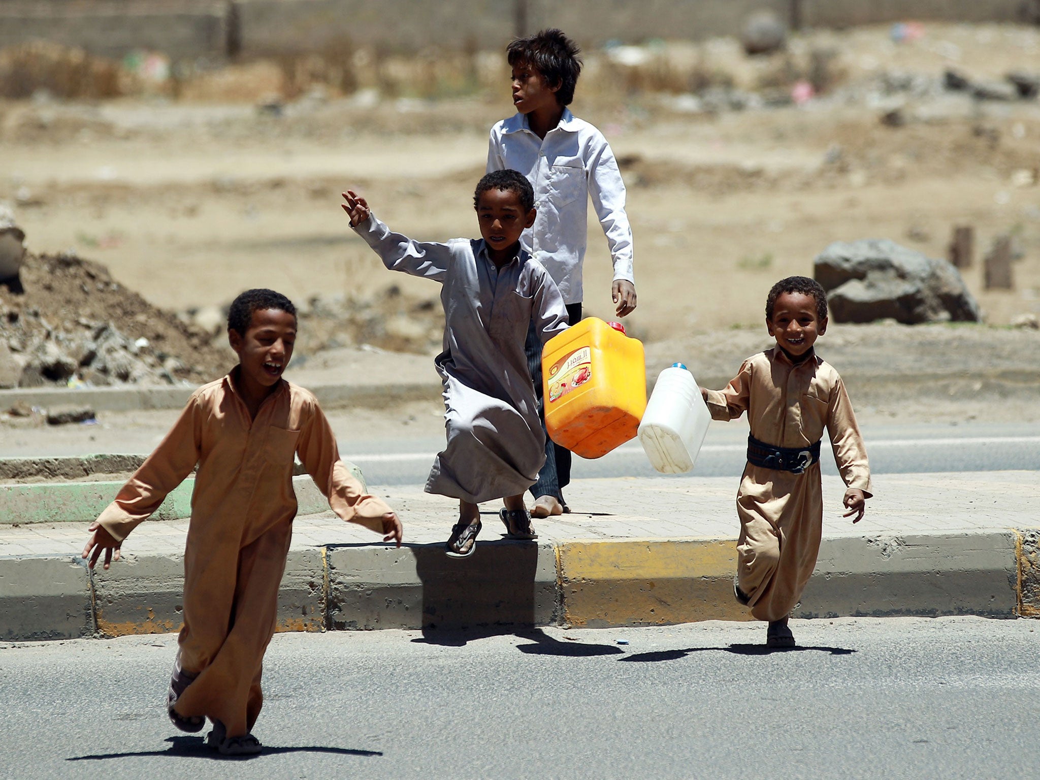Yemeni young boys carry plastic jerry cans as they arrive to fill them at a public tap at a slum in the capital Sanaa
