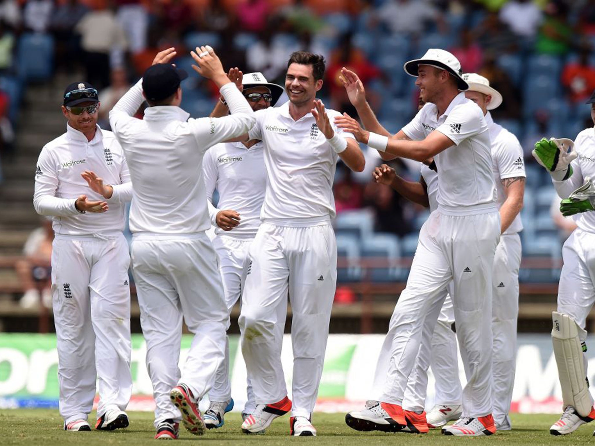 Jimmy Anderson celebrates one of his four wickets with his England team-mates in Grenada on Saturday night