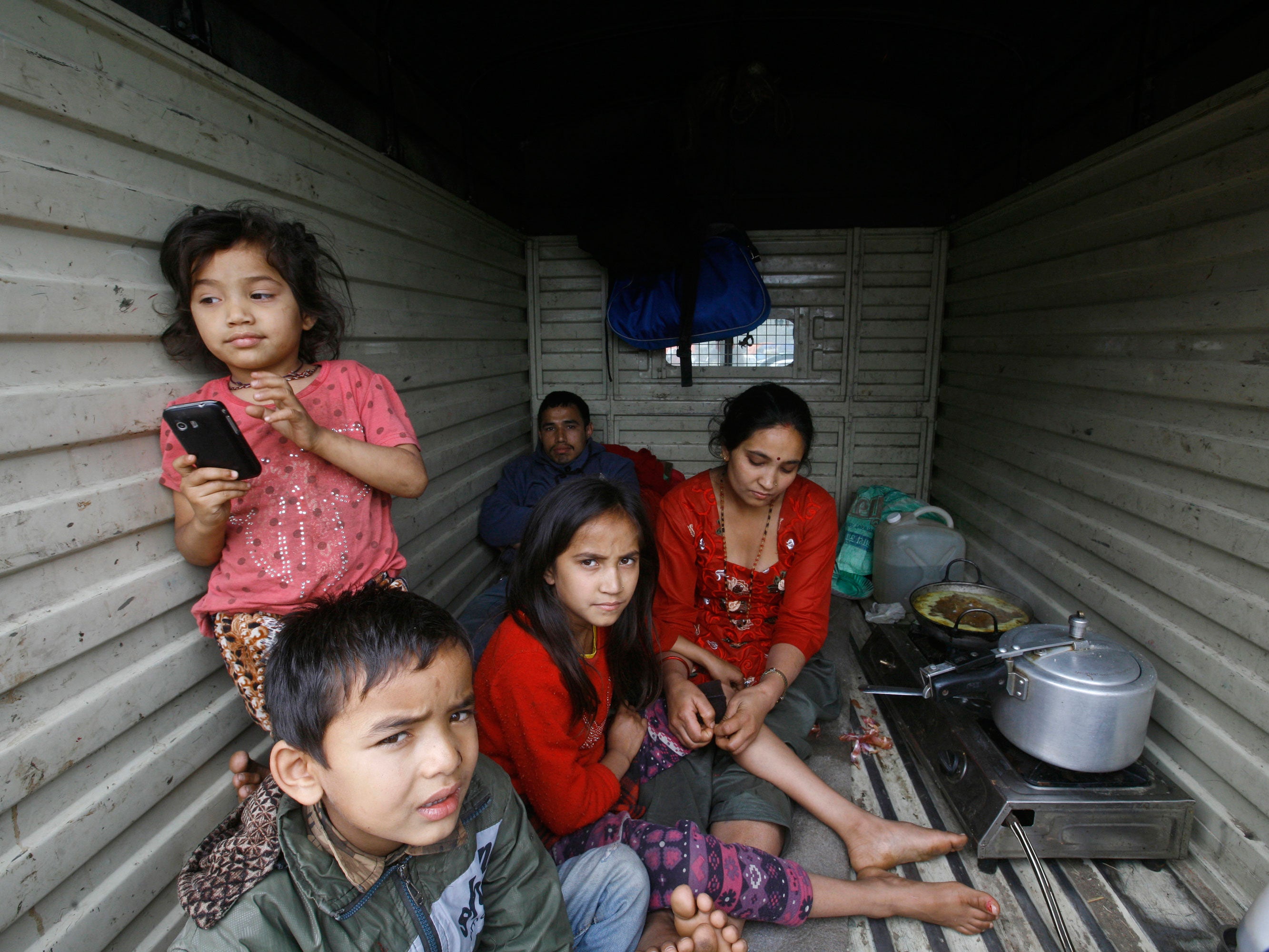 People rest inside a van where they have taken shelter as it is considered safer in cars than inside houses due to the repeated aftershocks