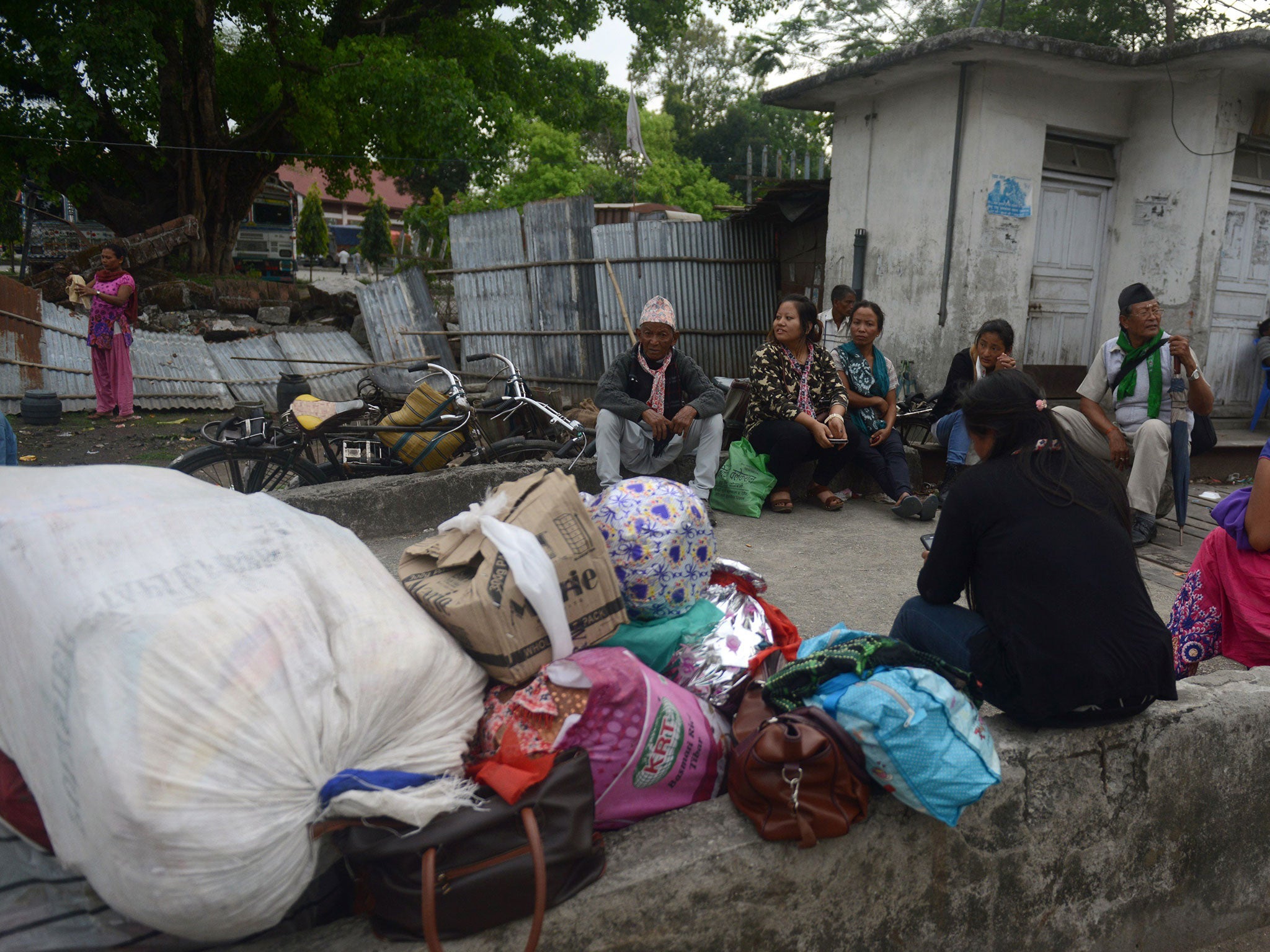 Nepalese residents gather outside their homes in Dhulabari village in eastern Nepal a day after an earthquake hit
