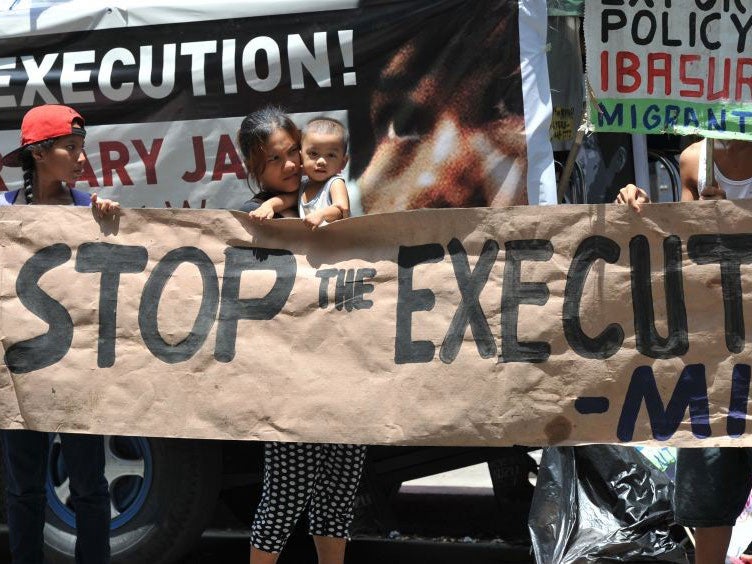 Activists hold a banner during a protest in front of the Indonesian embassy in Manila