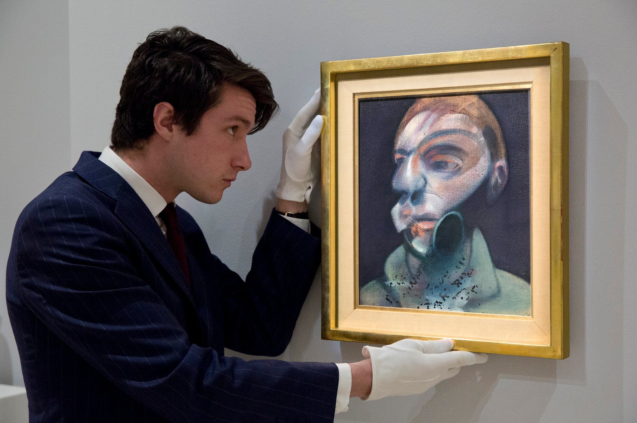 A Sotheby's art handler with Self-Portrait (1975) by Francis Bacon, which will be put on public exhibition for the first time