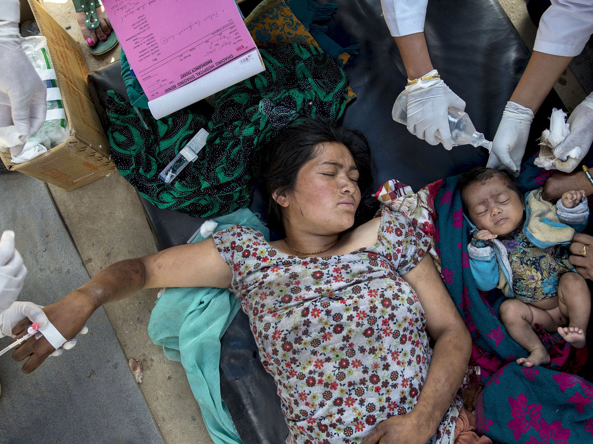 An injured woman and her daughter receive medical treatment after arriving at Dhading hospital, in the aftermath of the earthquake, in Dhading Besi