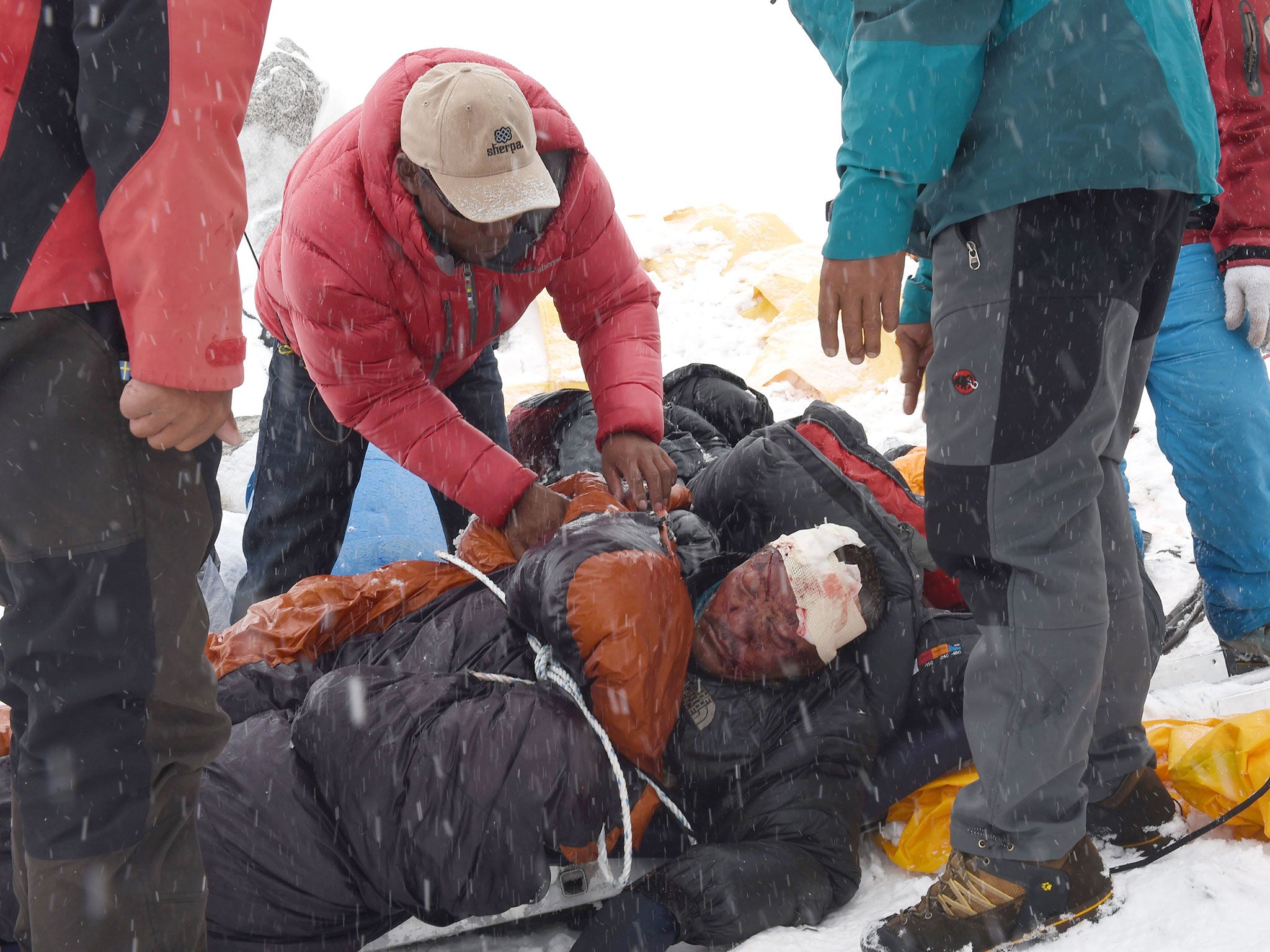 Rescuers tend to a sherpa injured by an avalanche that flattened parts of Everest Base Camp. Rescuers in Nepal are searching frantically for survivors of a huge quake, that killed more than 3,000 people, digging through rubble in the devastated capital Kathmandu and airlifting victims of an avalanche at Everest base camp