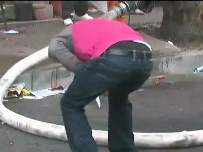 A man is seen puncturing a fire hose with a knife during riots in Baltimore