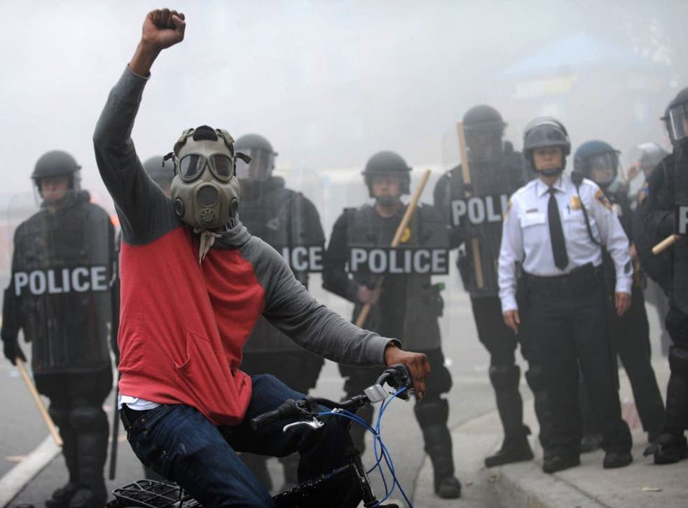 The man who slashed the fire hose poses in front of a police line in Baltimore on 27 April