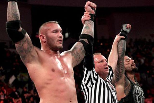 Randy Orton and Roman Reigns celebrate defeating Seth Rollins and Kane