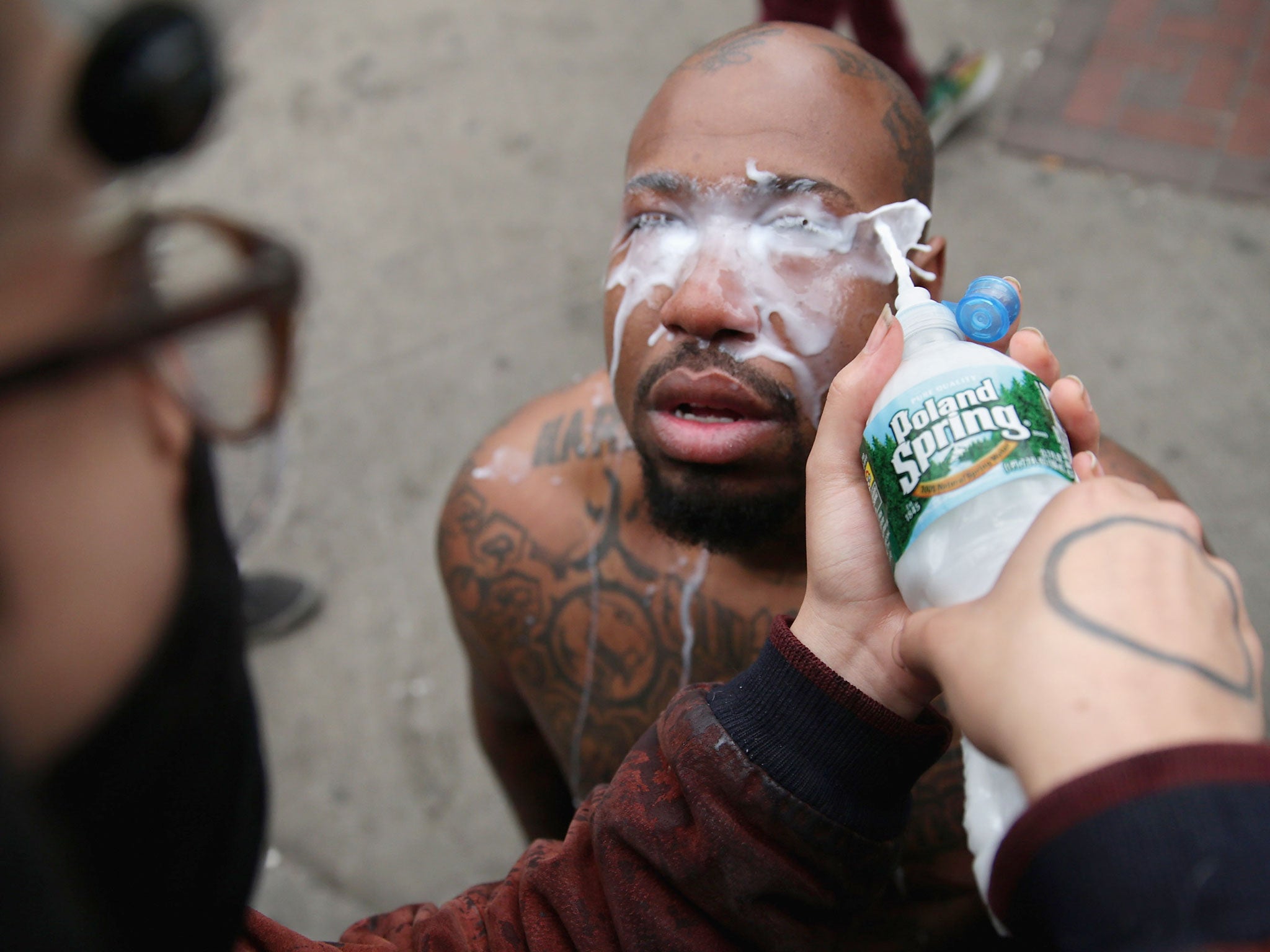 A man has his eyes cleaned after he was pepper sprayed by the Baltimore Police at the corner of Pennsylvania and North avenues during violent protests following the funeral of Freddie Gray in Baltimore