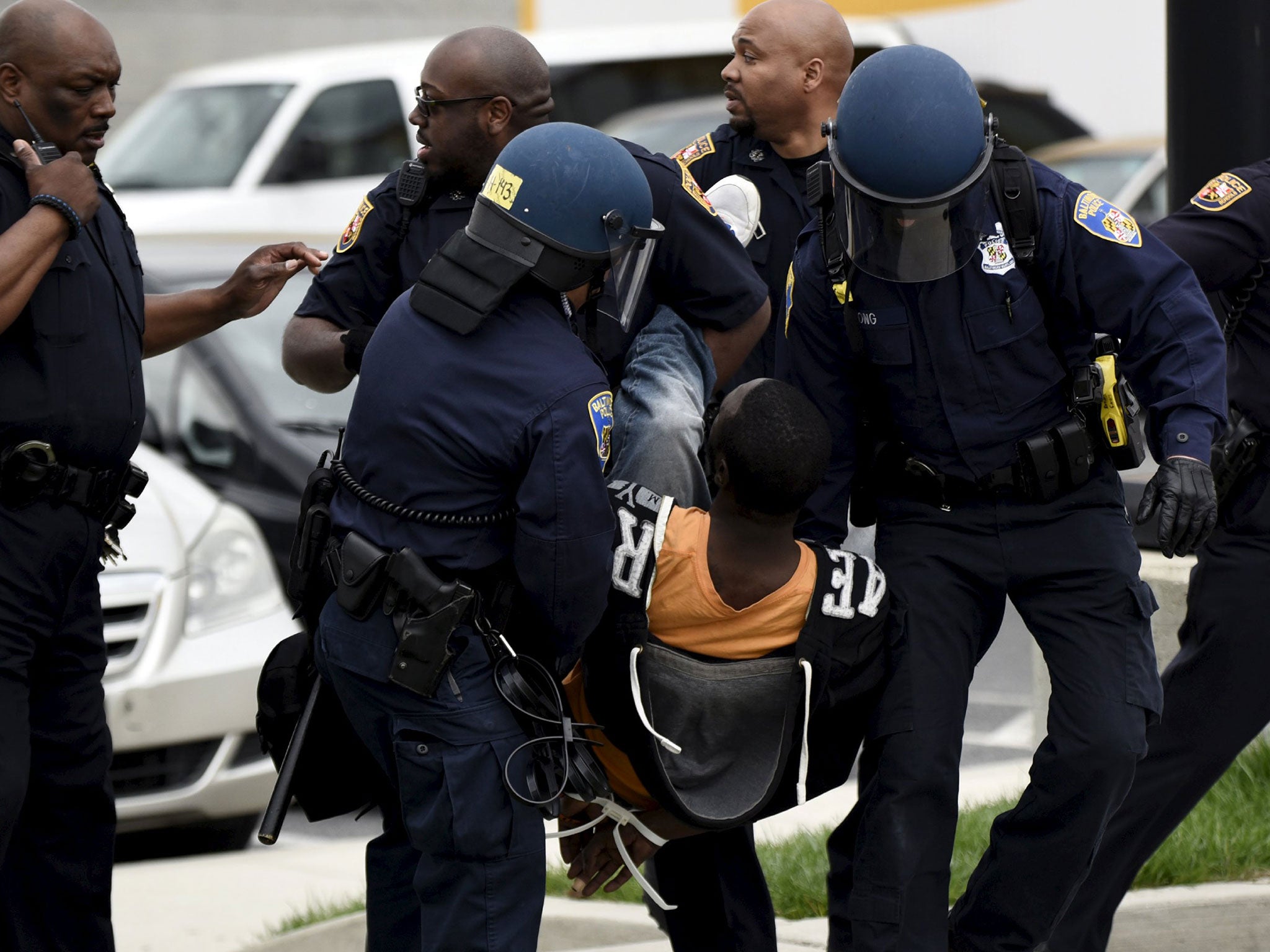 Policemen detain a protester near Mondawmin Mall