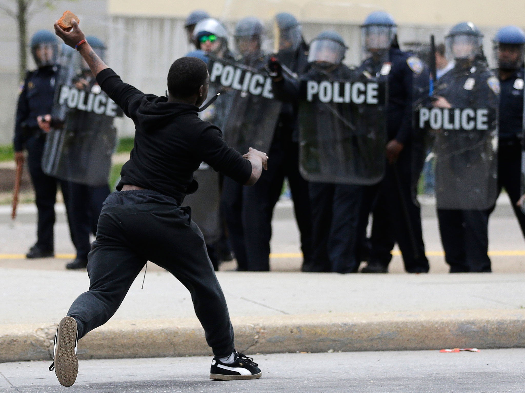 A man throws a brick at police, following the funeral of Freddie Gray in Baltimore