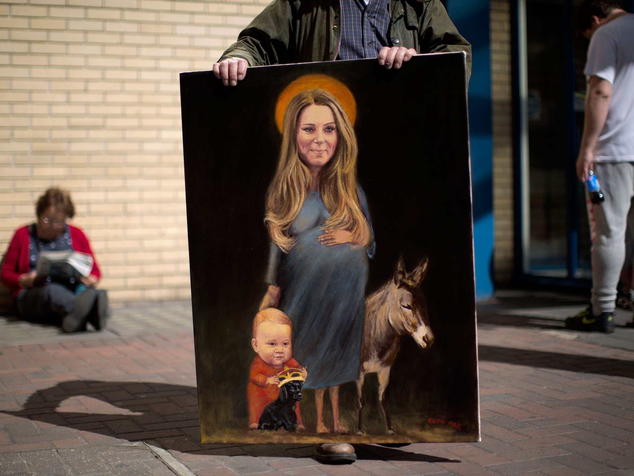 Artist Kaya Mar holds his painting entitled "Saint Kate" across the street from the Lindo Wing of St Mary's Hospital in London