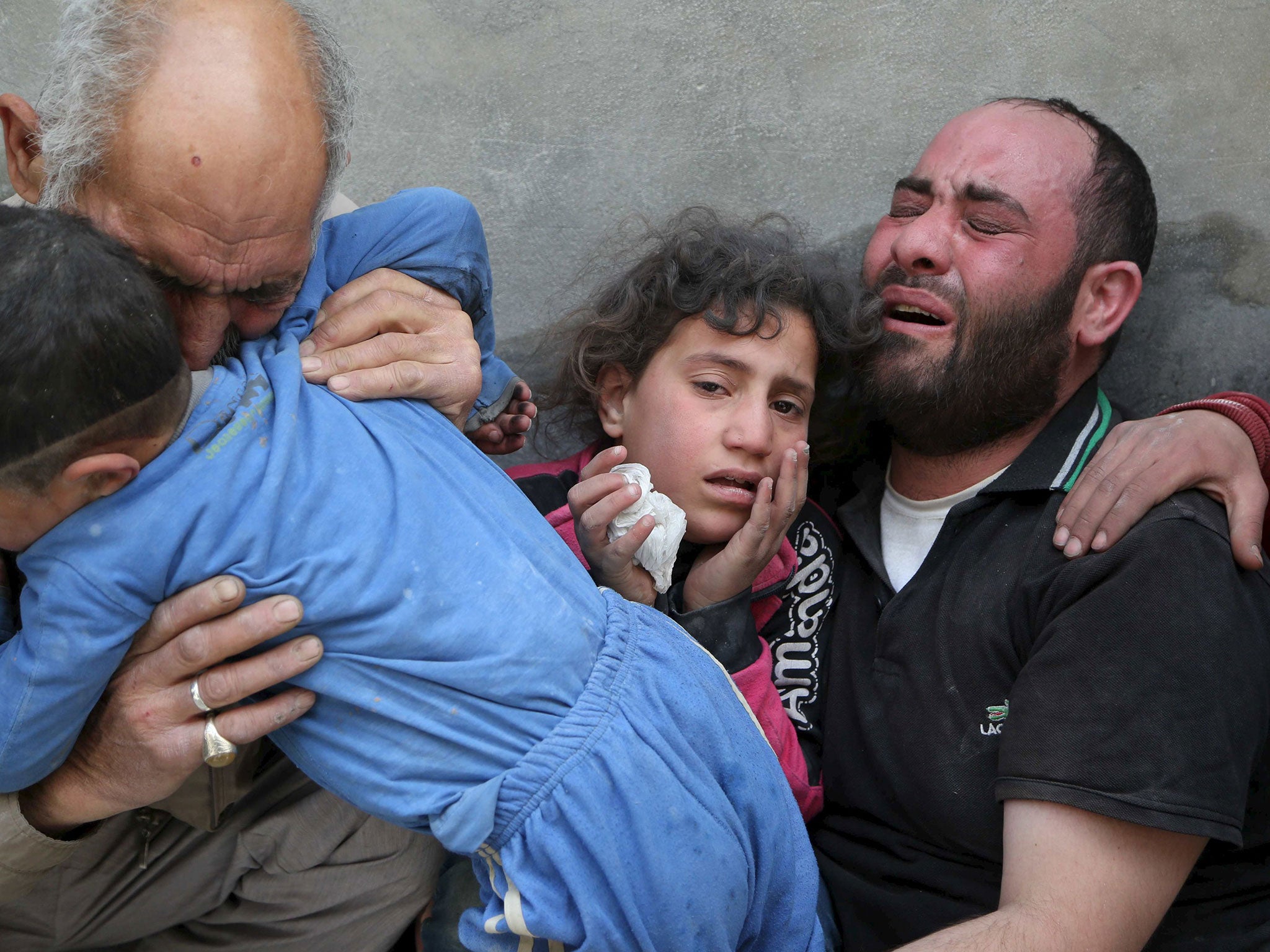A family mourns the loss of their relatives to what activists say was a barrel bomb dropped by forces loyal to Syria's President Bashar al-Assad, in Aleppo's al-Fardous district