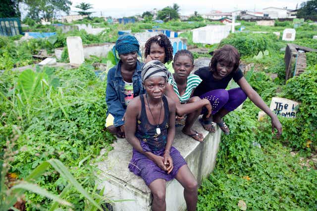 A group of female tomb dwellers sit on top of their make-shift home in Monrovia, Liberia