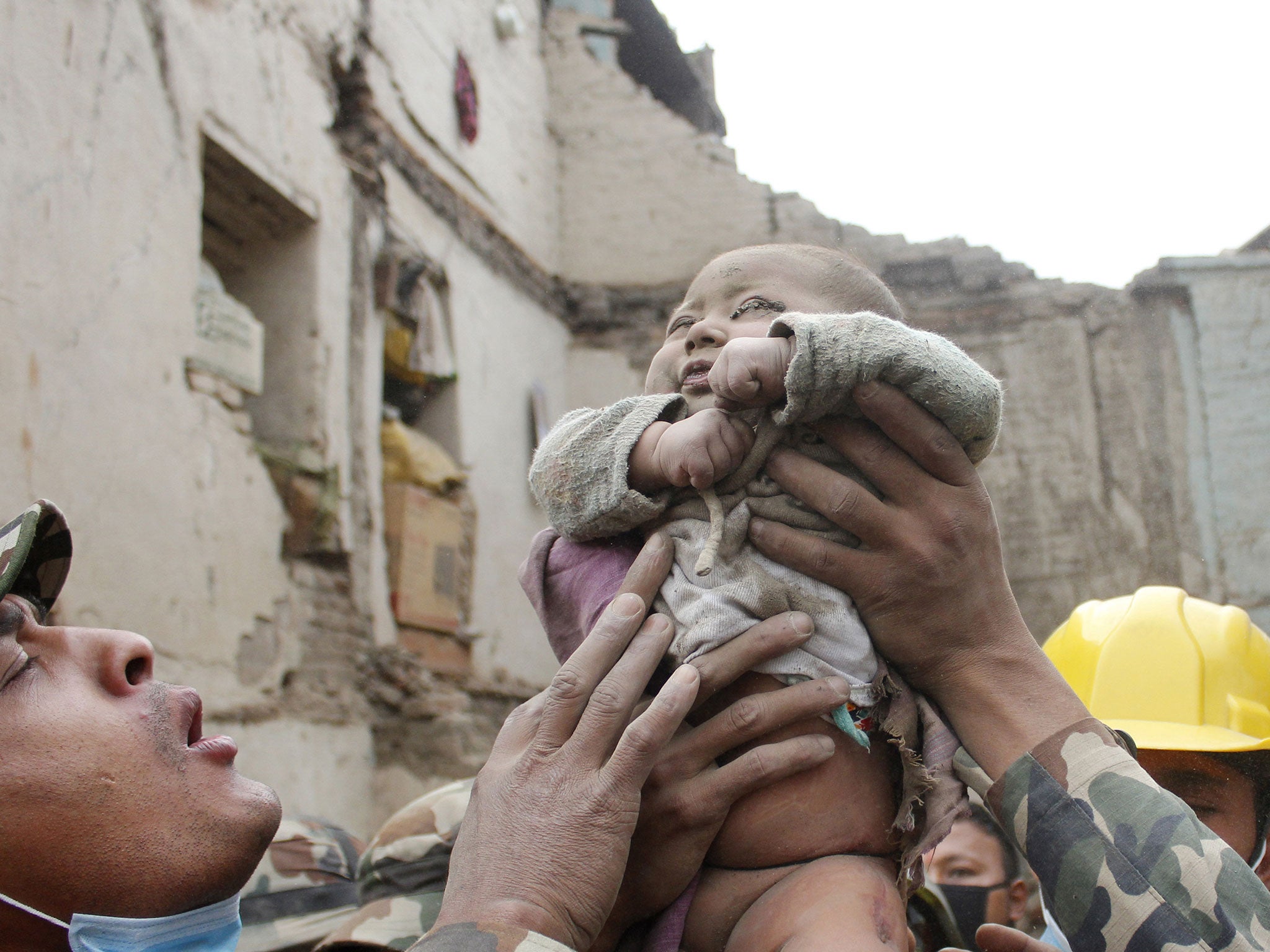 Four-month-old baby boy Sonit Awal is held up by Nepalese Army soldiers after being rescued from the rubble of his house in Bhaktapur, Nepal