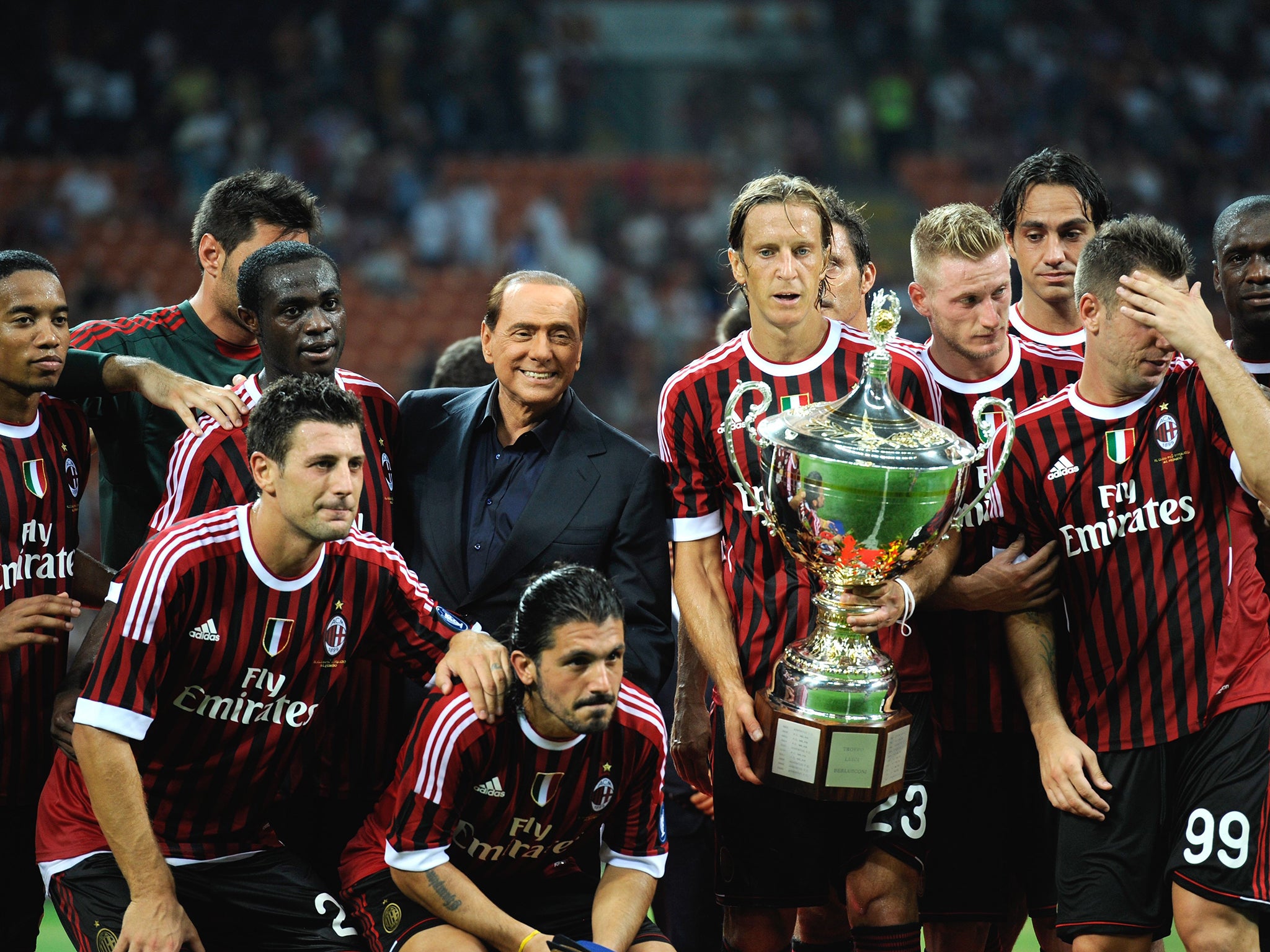 Even AC Milan, one of the jewels in the business empire of Silvio Berlusconi
(centre) is up for grabs