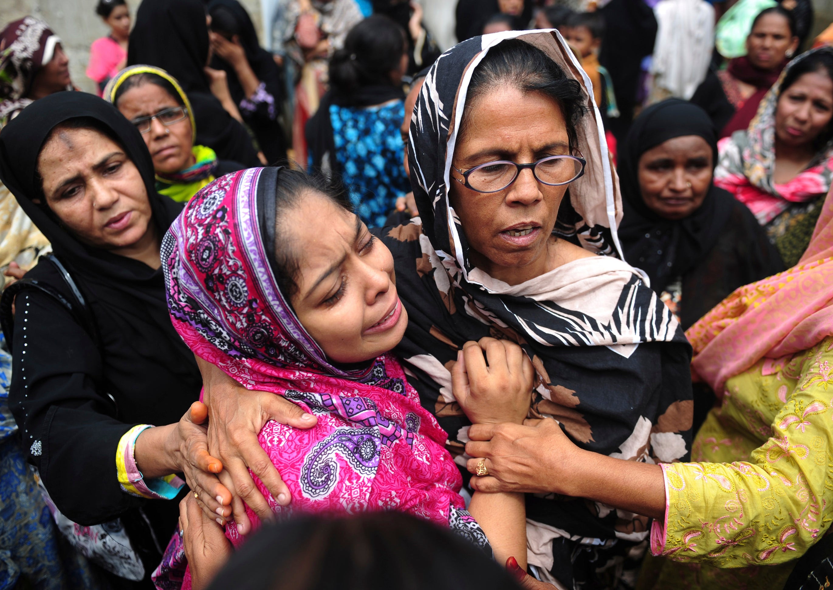 Relatives mourn the death of a loved one during a funeral for a garment factory victim in Karachi (Getty)