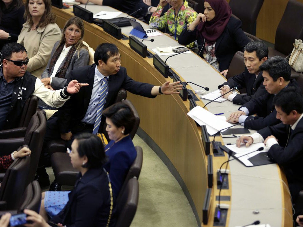 North Korean defectors, left, argue with North Korean diplomats, right, at United Nations headquarters