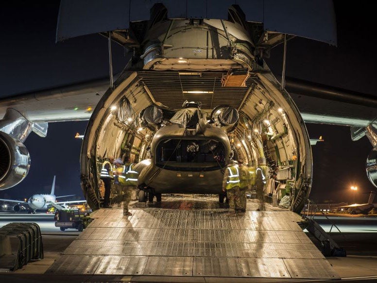 A Chinook helicopter carrying emergency supplies being loaded on a transport plane to help the rescue effort in Nepal