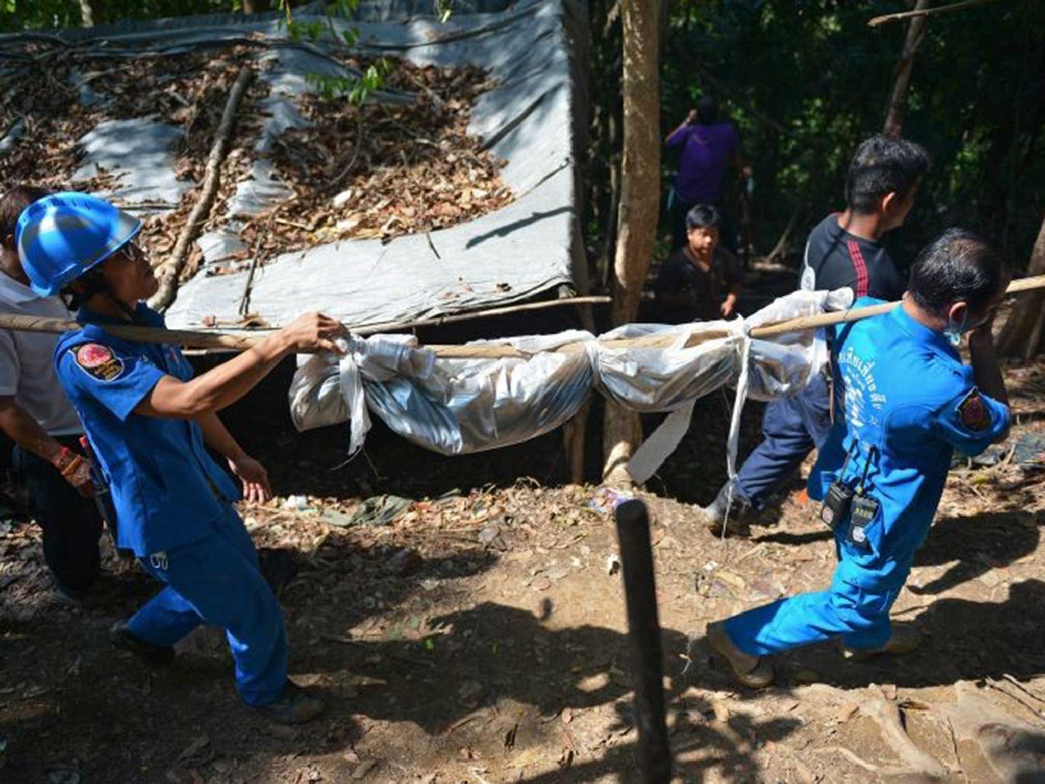 One of the bodies is carried out of the camp