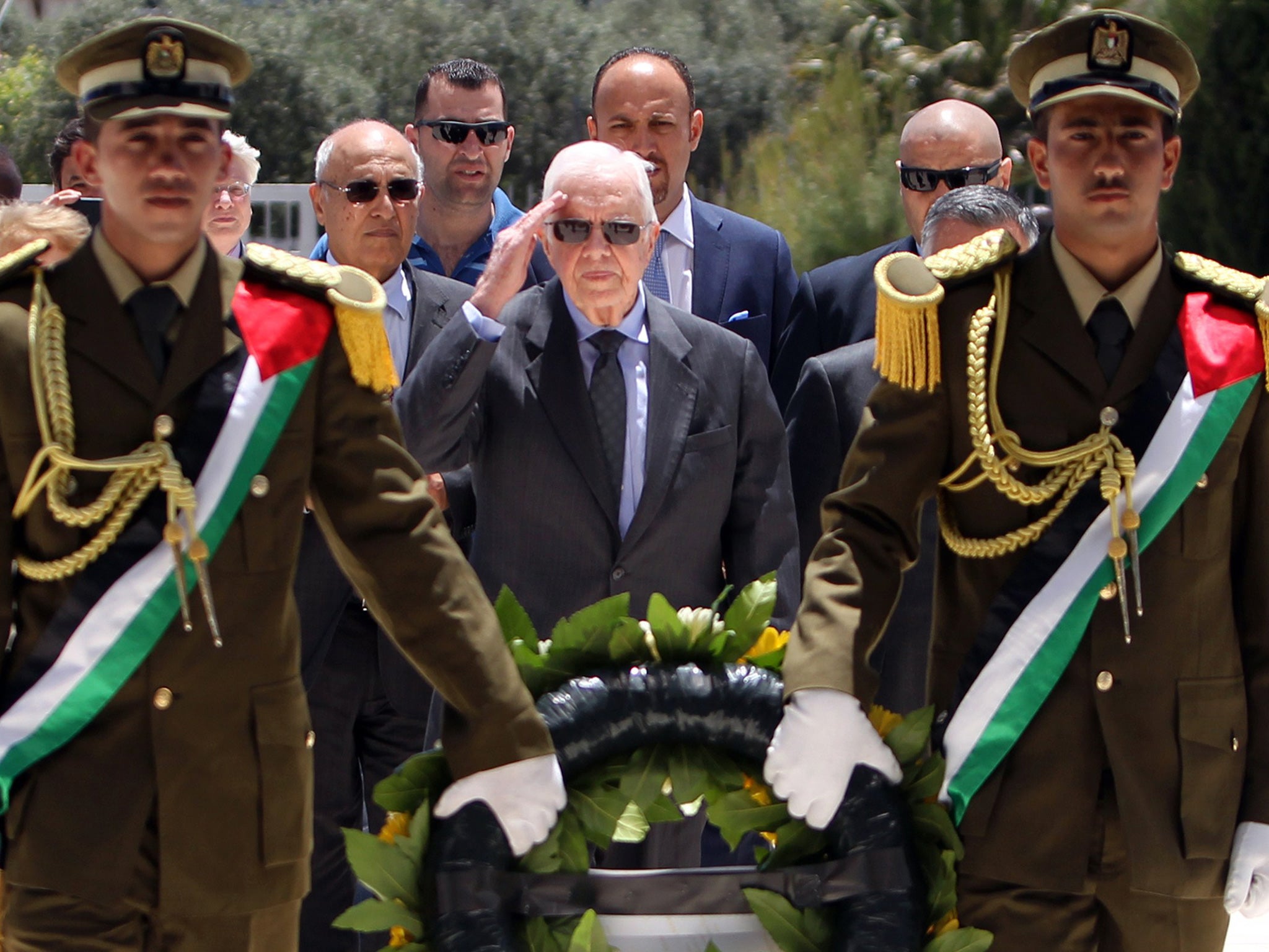Jimmy Carter (centre) prepares to lay a wreath of flowers on the tomb of the late Palestinian leader Yasser Arafat