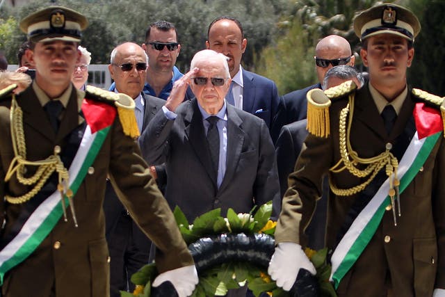 Jimmy Carter (centre) prepares to lay a wreath of flowers on the tomb of the late Palestinian leader Yasser Arafat