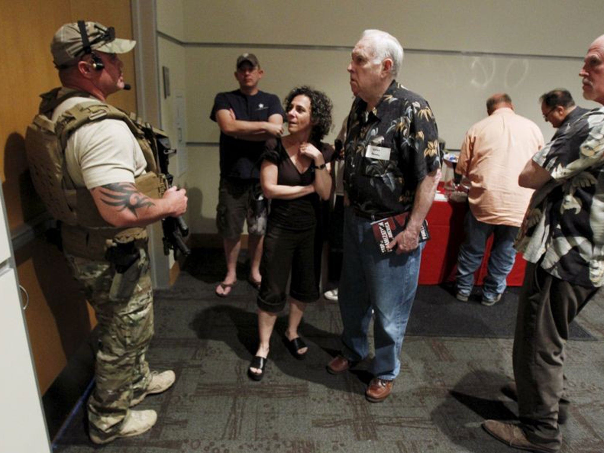 A police officer prevents attendees from leaving the Muhammad Art Exhibit and Contest after shots were fired outside the venue in Texas.