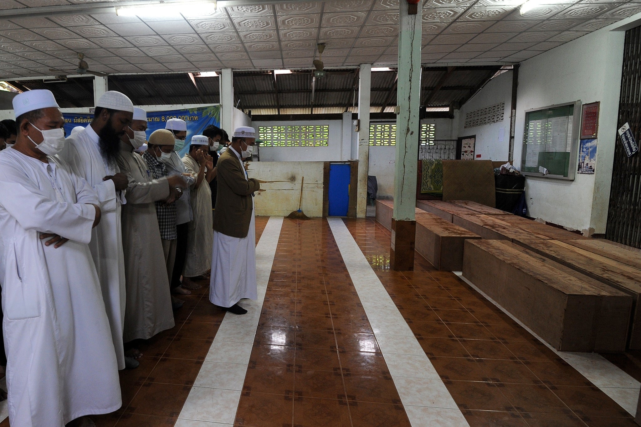 Muslim leaders give prayers over the coffins of those found in the mass grave