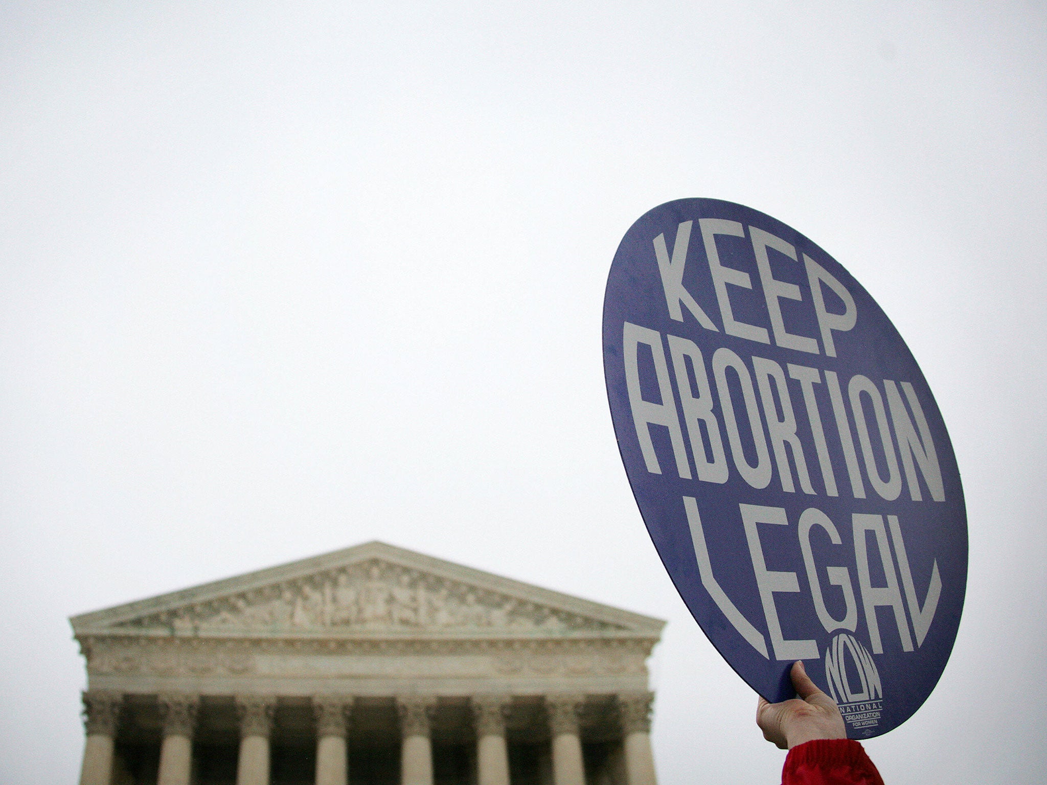 A pro-choice demonstrator holds up a placard outside the US Supreme Court (rear) in Washington, DC, 08 November 2006 as the court hears oral arguments in the partial-birth abortion ban case. The court is weighing in on the constitutionality of a law banning a surgical method to terminate a pregnancy