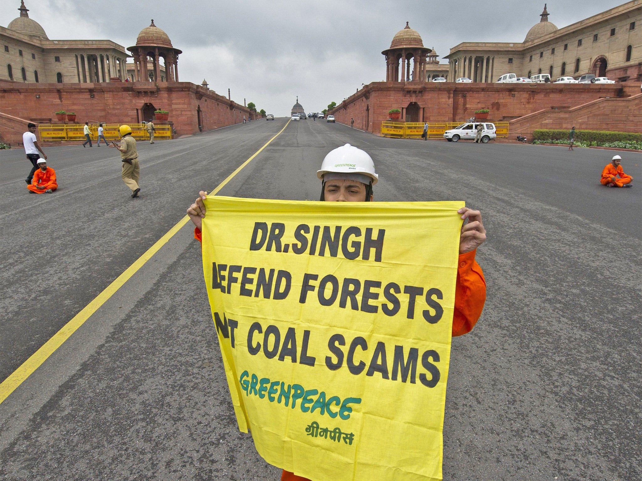 A Greenpeace activist holds a poster against alleged coal scams near the Indian Parliament in New Delhi