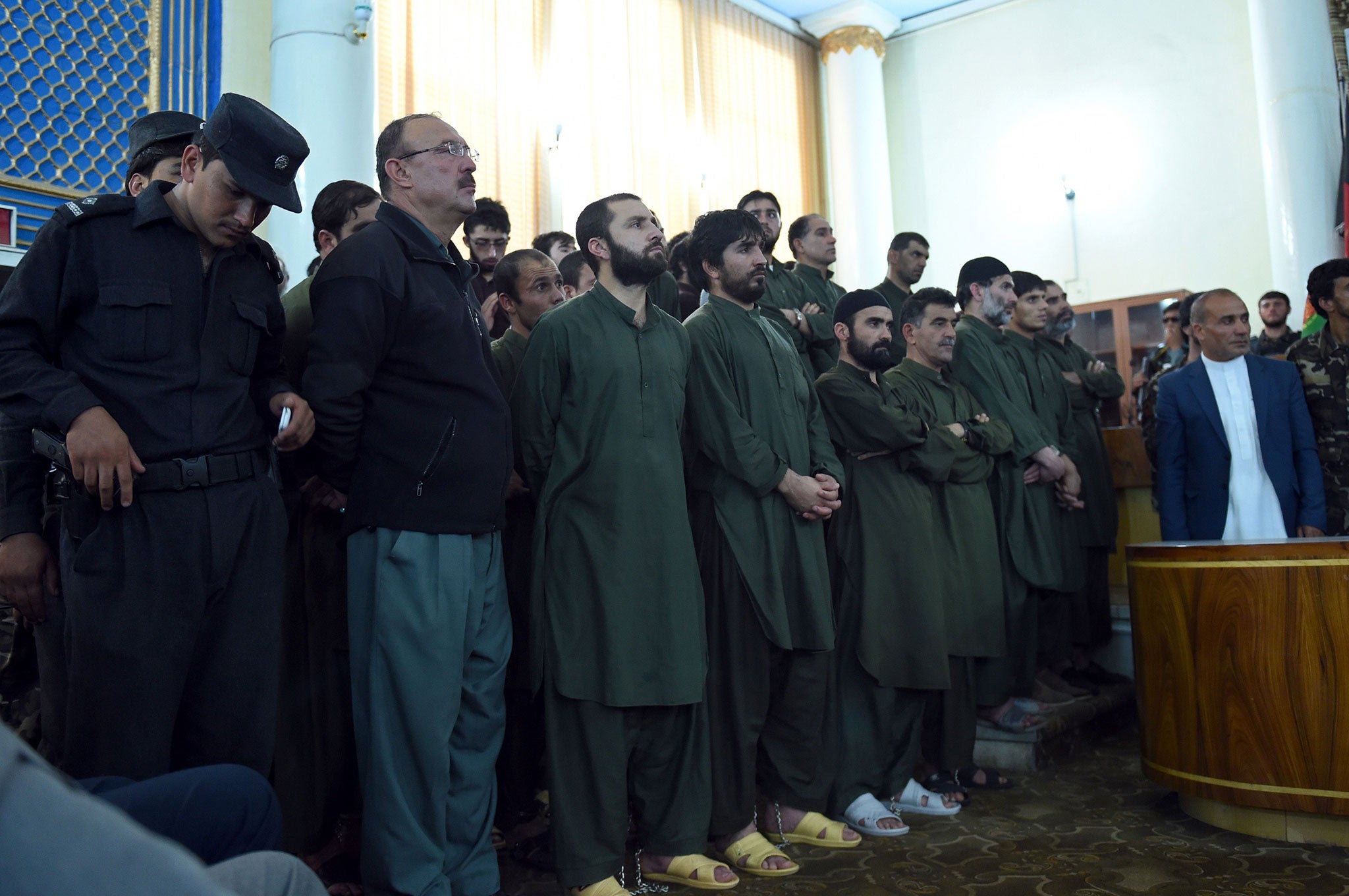 Suspects stand before a judge during a primary court trial in Kabul, on charges relating to the mob killing of a 27-year-old Afghan woman