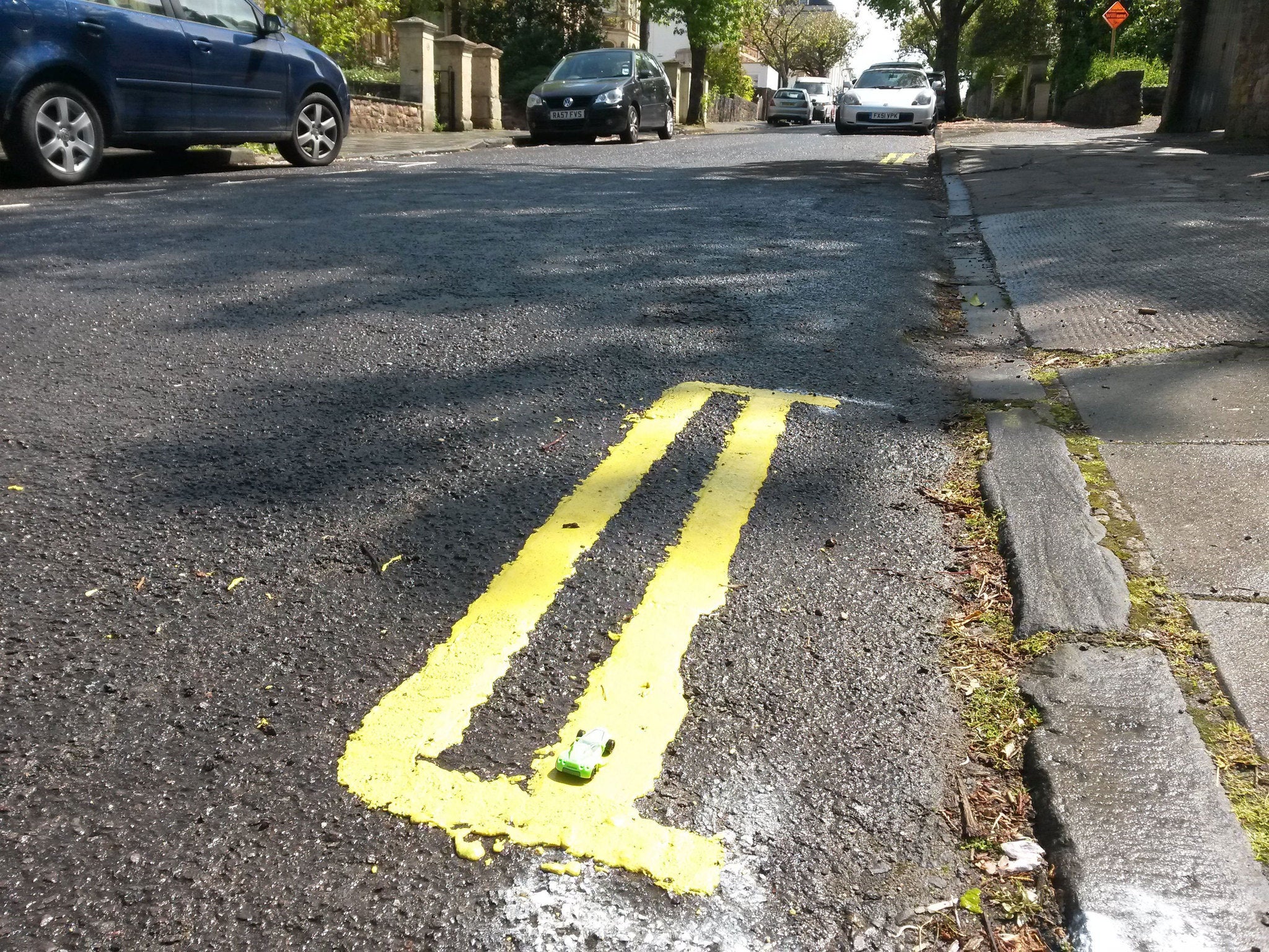 A set of double yellow lines on Leigh Road in Bristol measuring less than a metre long on a residential street.