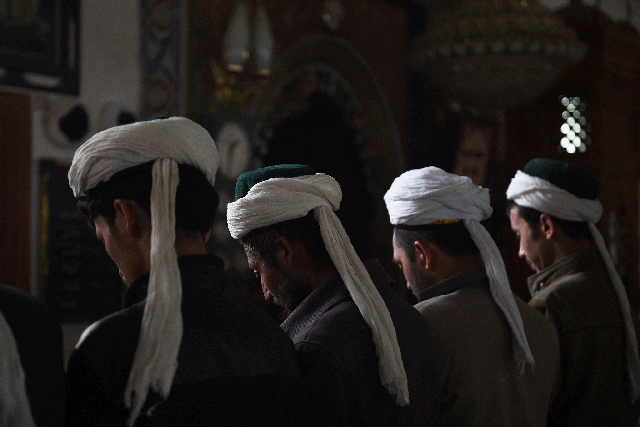 Uighur men praying in a mosque in Hotan, in China's western Xinjiang region, on 16 April, 2015