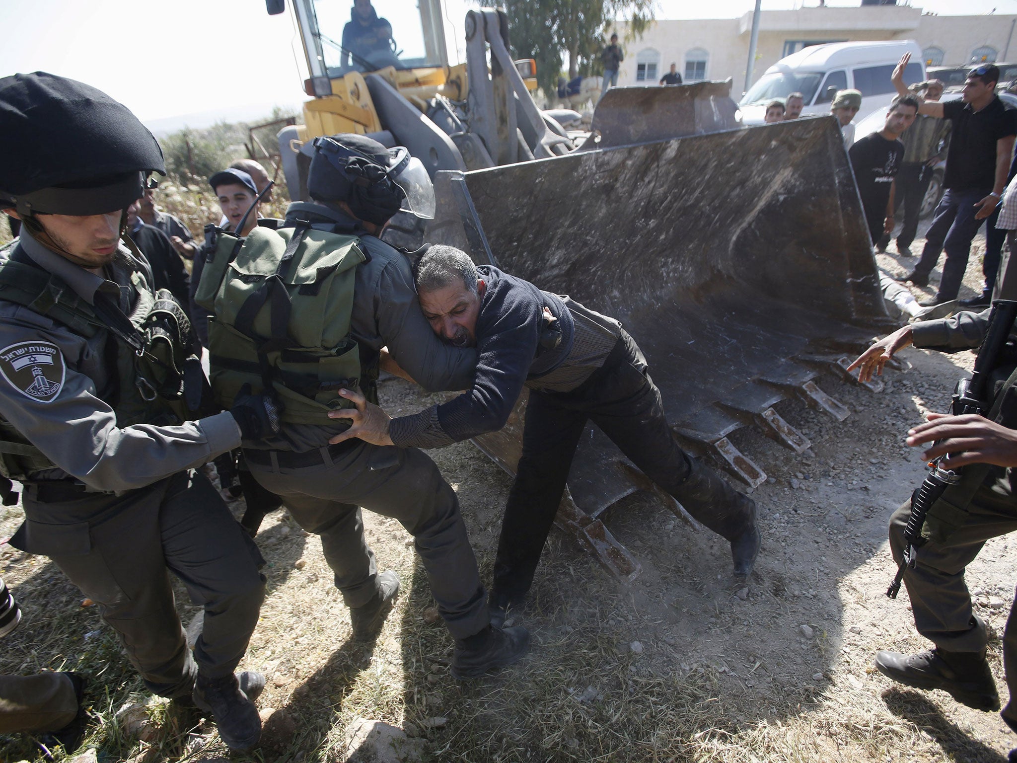 Israeli border policemen scuffle with a Palestinian man as Israeli forces bulldoze a farmland in Soba village near the West Bank city of Hebron. Palestinians said they were informed by the Israeli army that they do not have the needed Israeli-issued permi