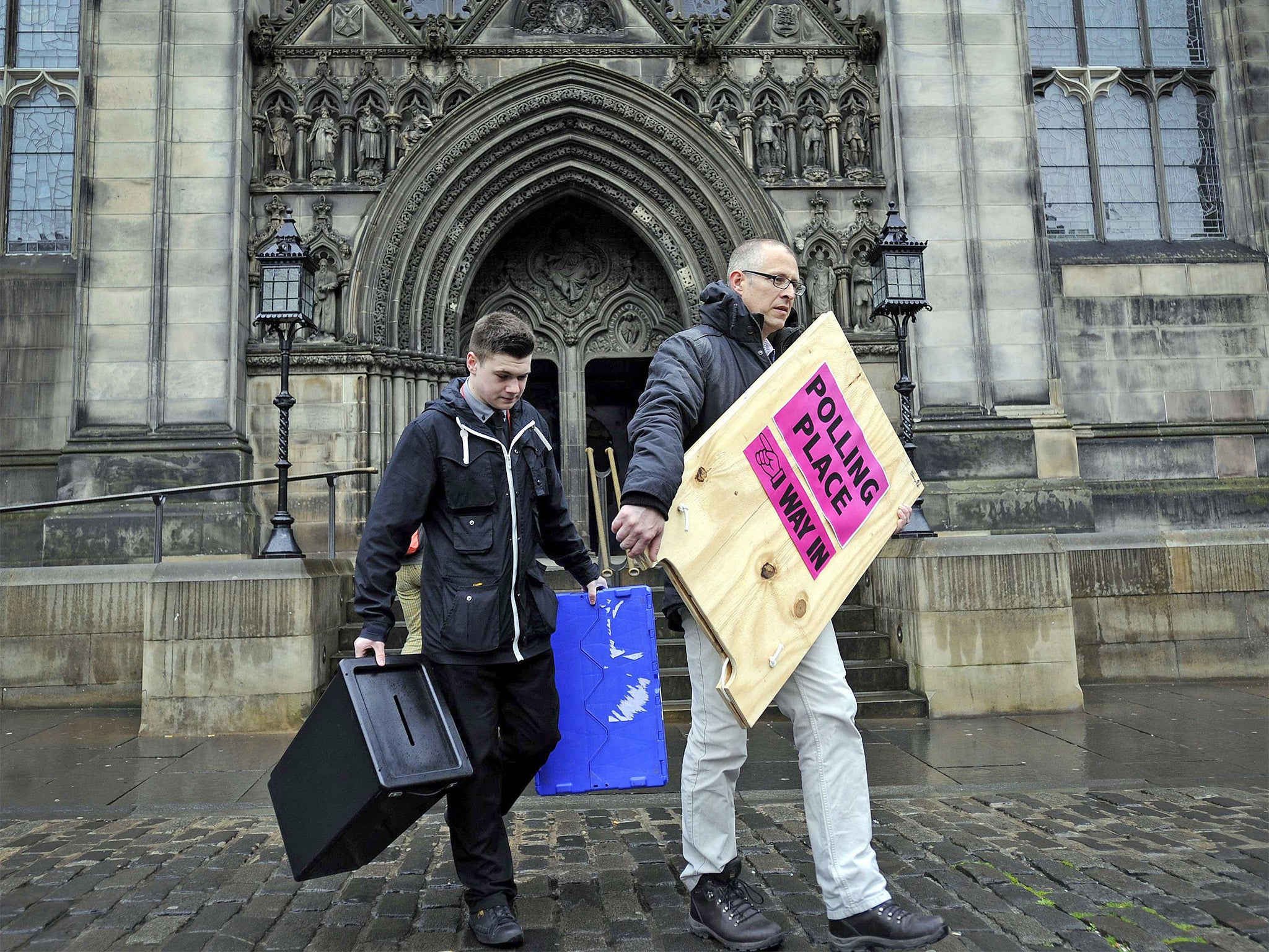 Staff deliver ballot boxes and signs to a polling station on Edinburgh’s Royal Mile on the eve of the election