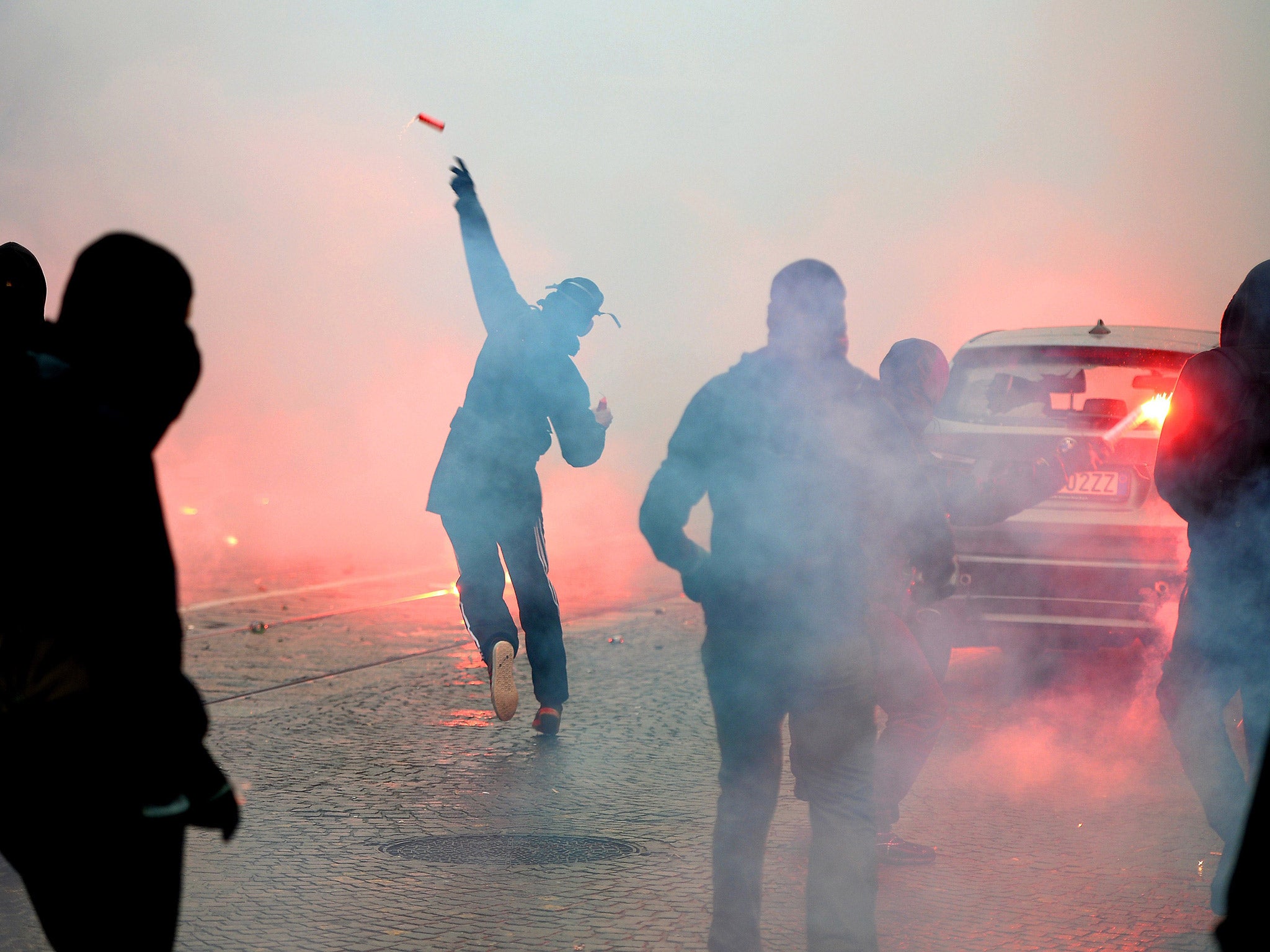 Protesters throw flares as they clash with police during last week's demonstration in Milan