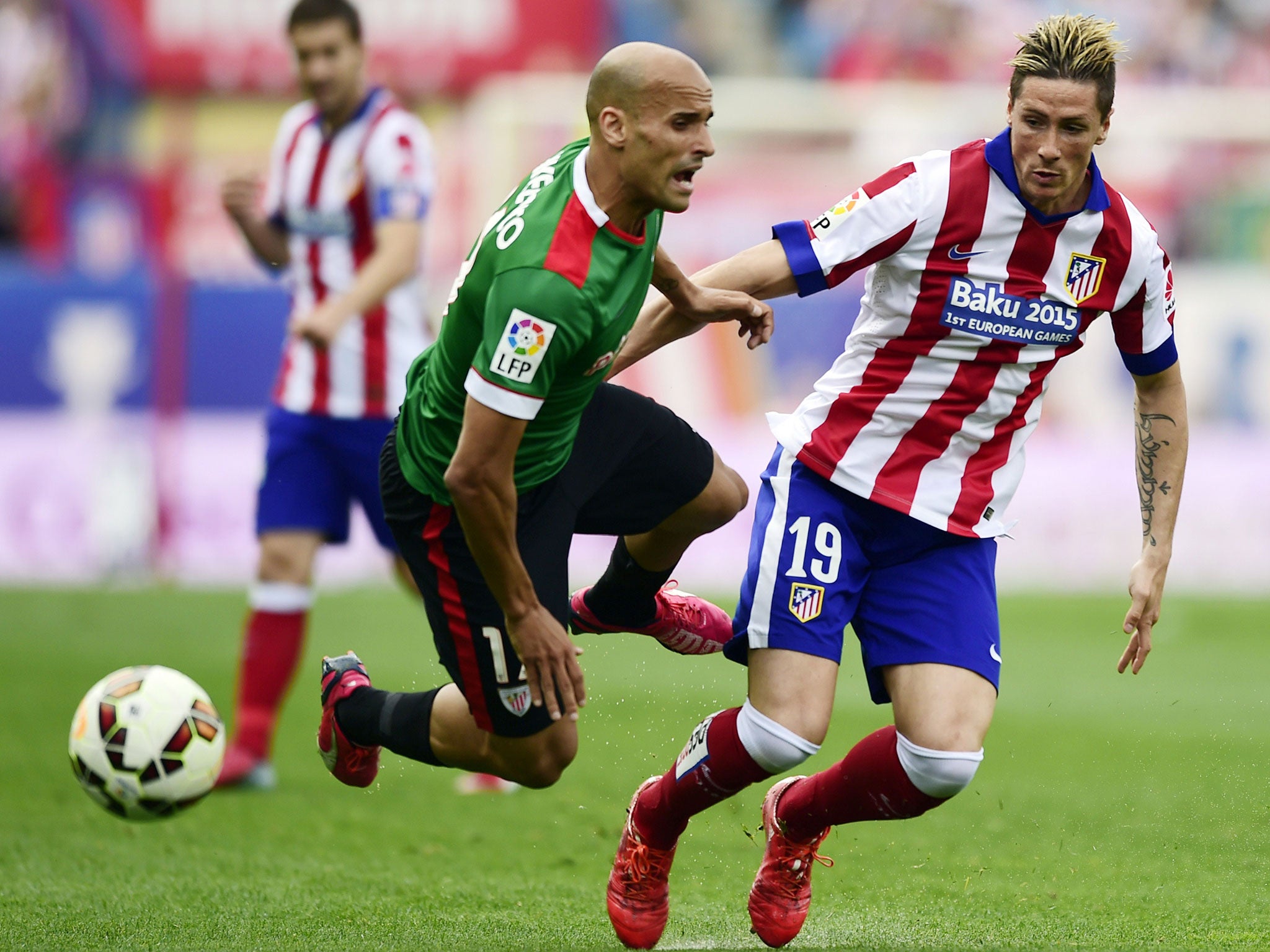 Atletico Madrid's forward Fernando Torres (R) vies with Athletic Bilbao's midfielder Mikel Rico during the Spanish league football match Club Atletico de Madrid vs Athletic Club Bilbao at the Vicente Calderon stadium in Madrid on May 2, 2015.