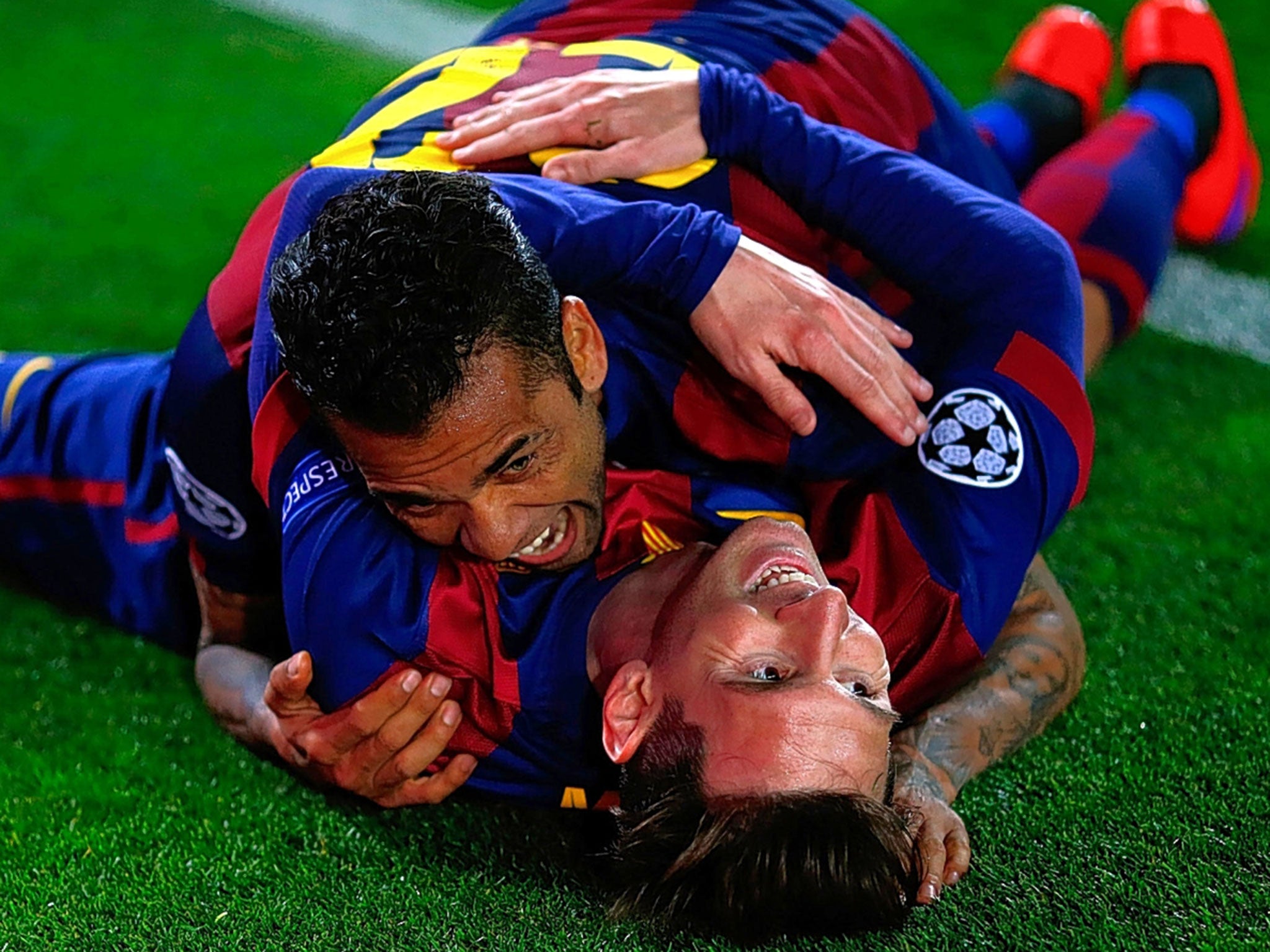 Lionel Messi (bottom) celebrates with Dani Alves after scoring his second goal for Barcelona