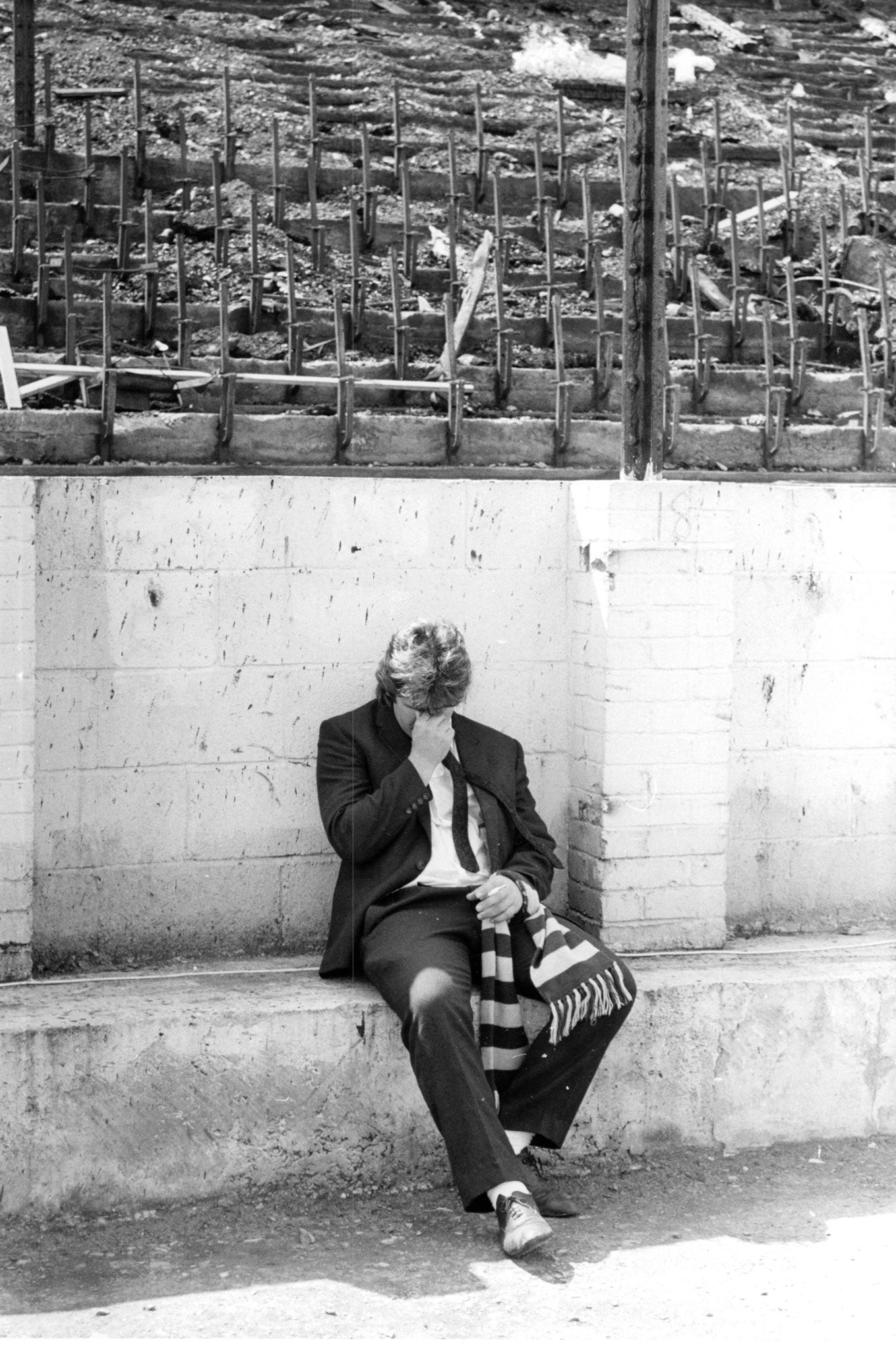 A relative of one of the victims breaks down amid the ruins of the stadium (Rex)