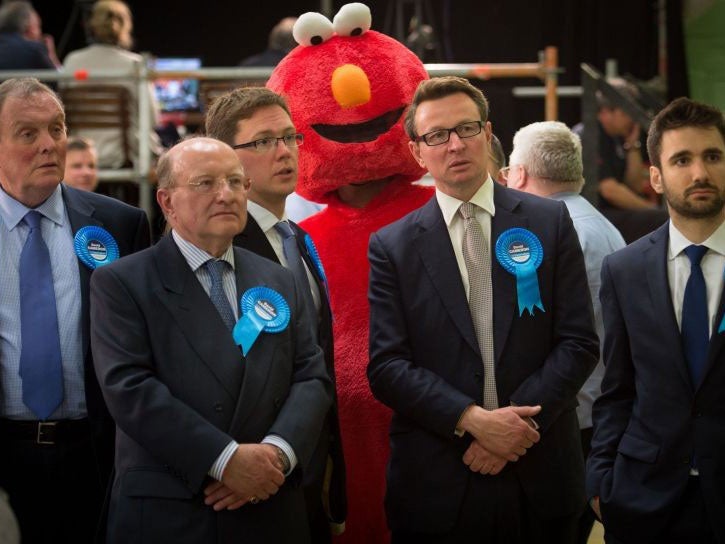 Conservative supporters and a man dressed as Elmo watch TV as General Election results come in at the Windrush Leisure Centre in Witney.